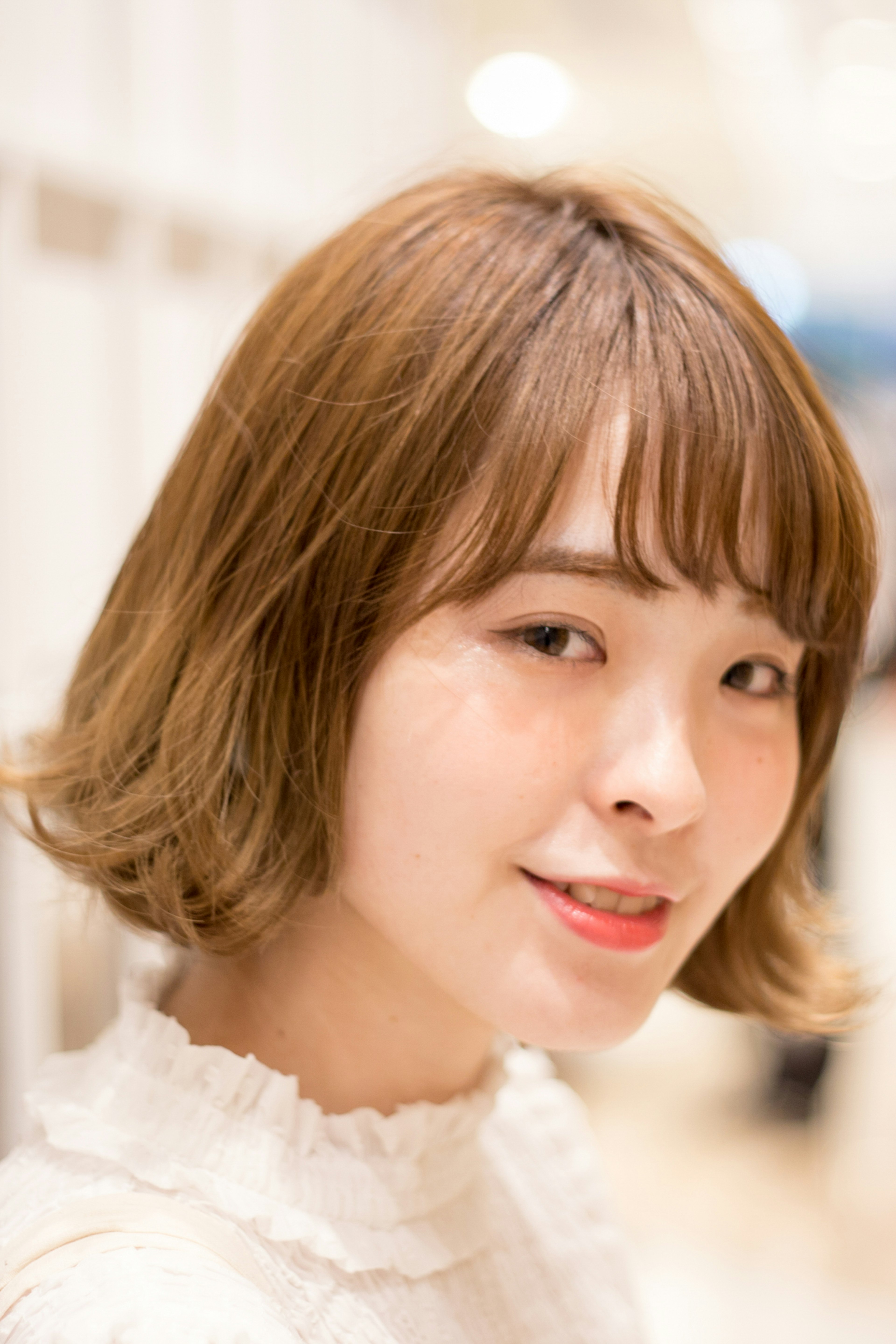 Young woman with short brown hair smiling in a portrait