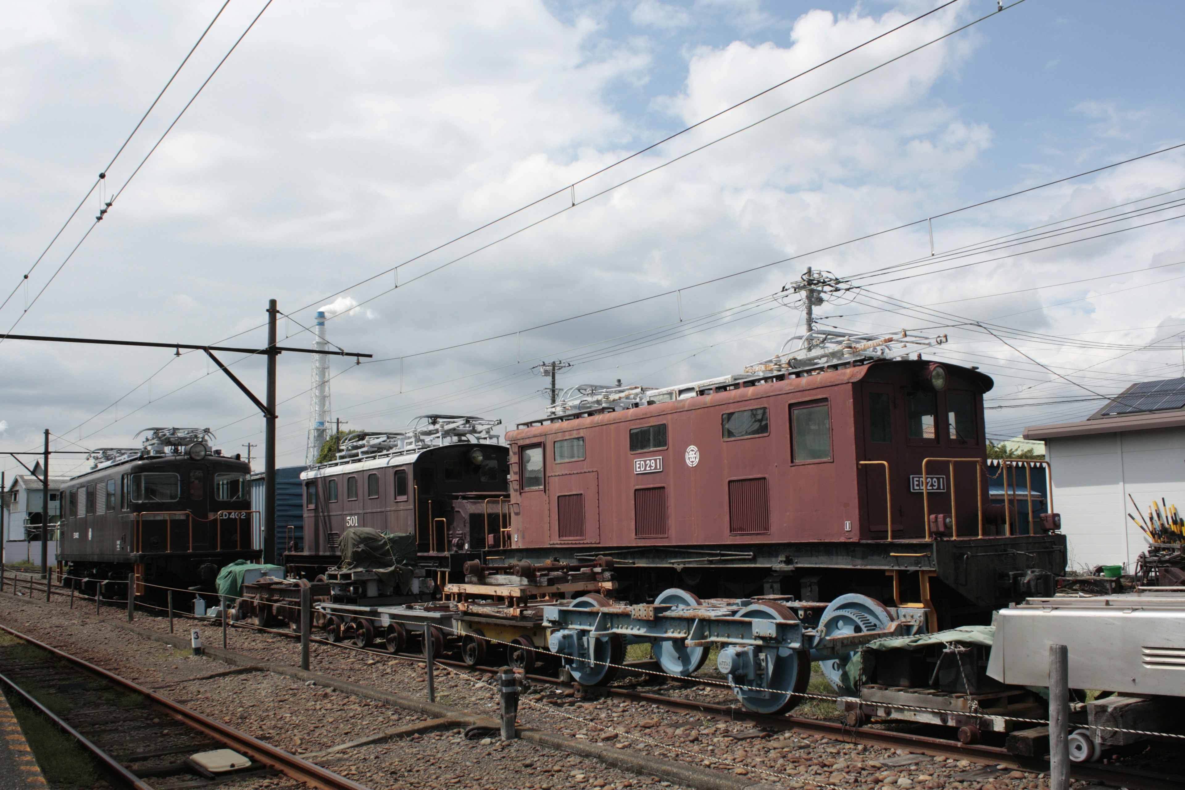 ทัศนียภาพของรถไฟที่เรียงรายอยู่ที่สถานีท่ามกลางท้องฟ้าสีฟ้าและเมฆสีขาว