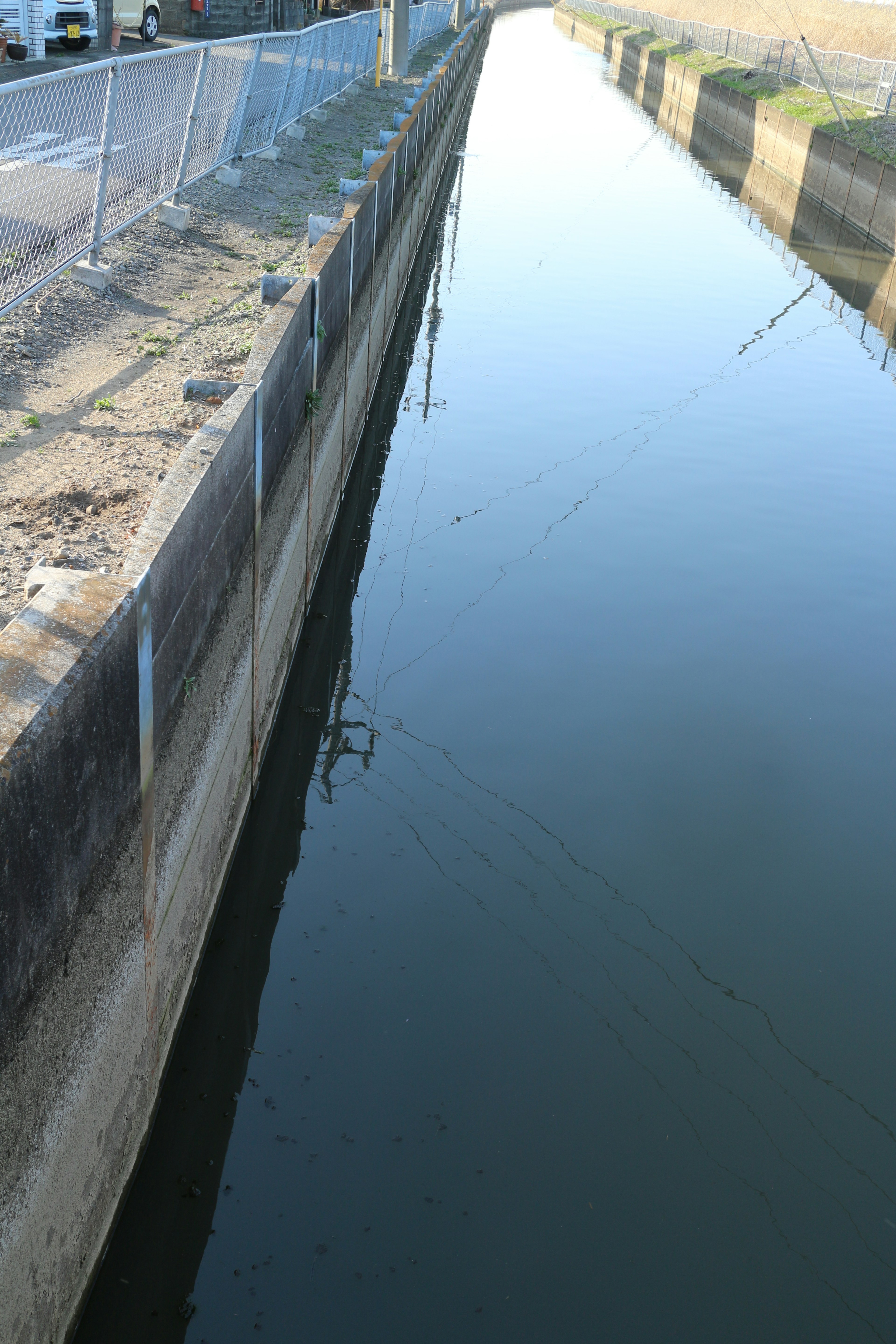 Vista escénica de un canal con agua corriente y paredes de concreto