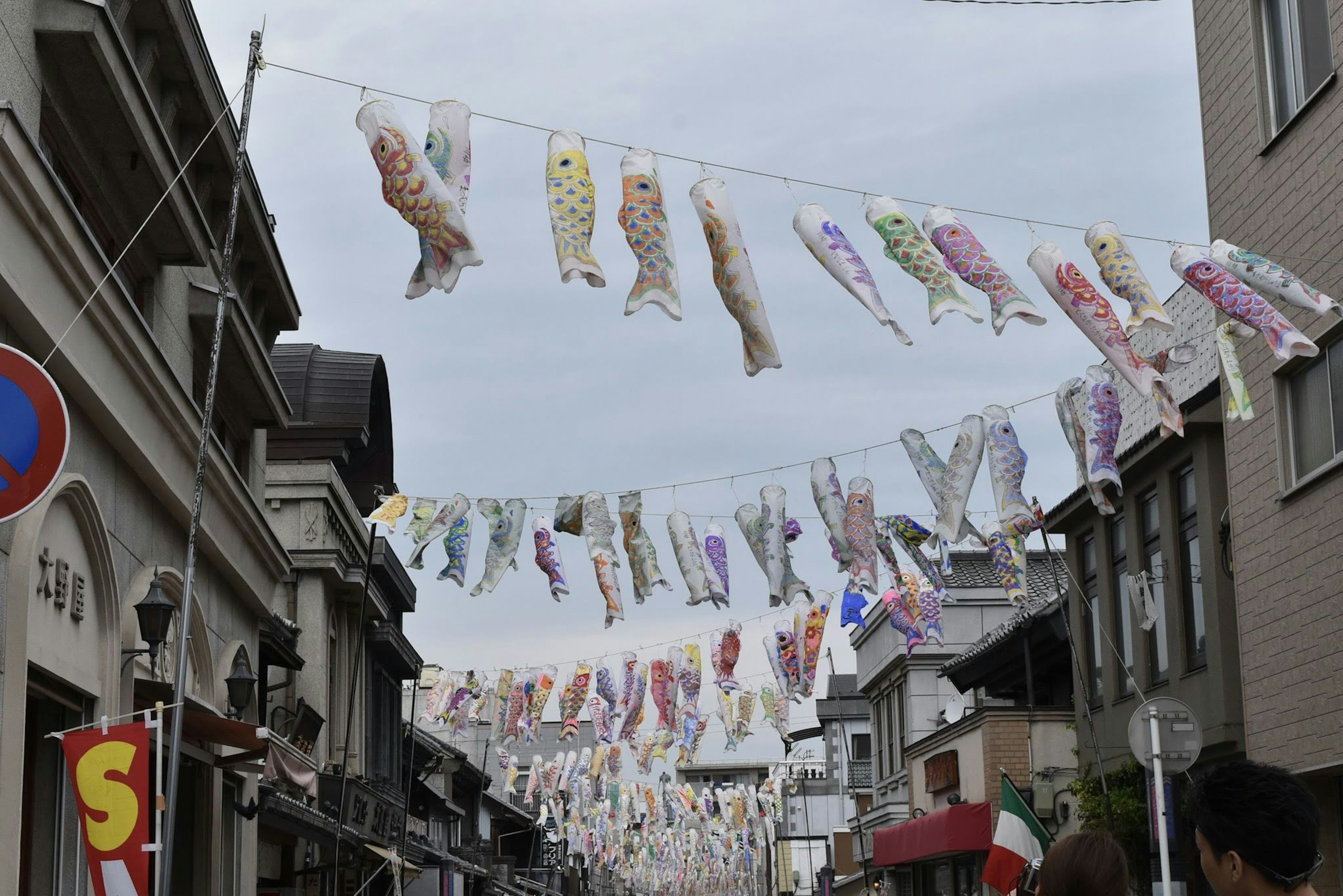 Bannières de poissons koi colorés suspendues au-dessus d'une rue commerçante