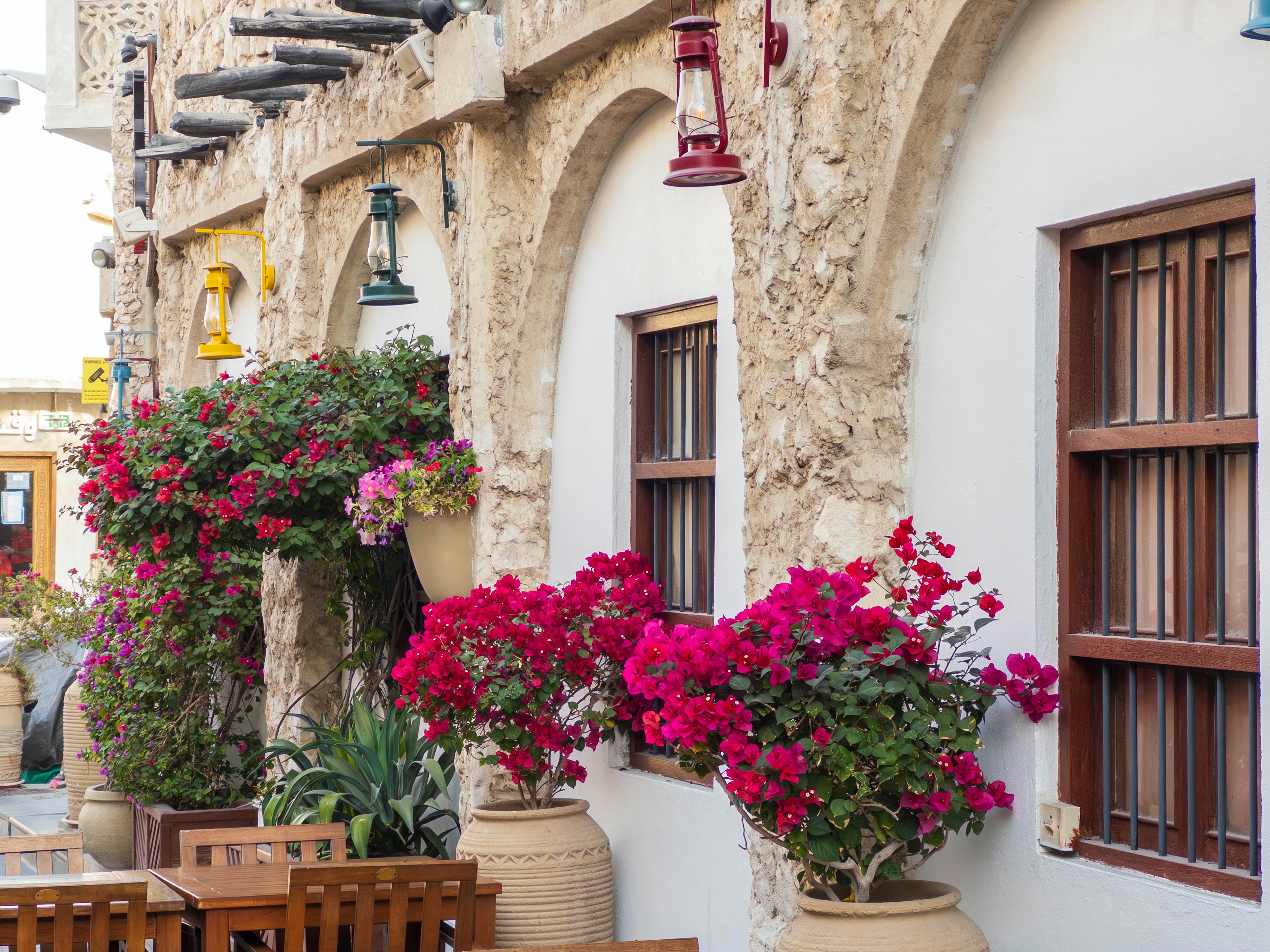 Bunte Blumen und Laternen, die die Fassade eines traditionellen katarischen Gebäudes schmücken