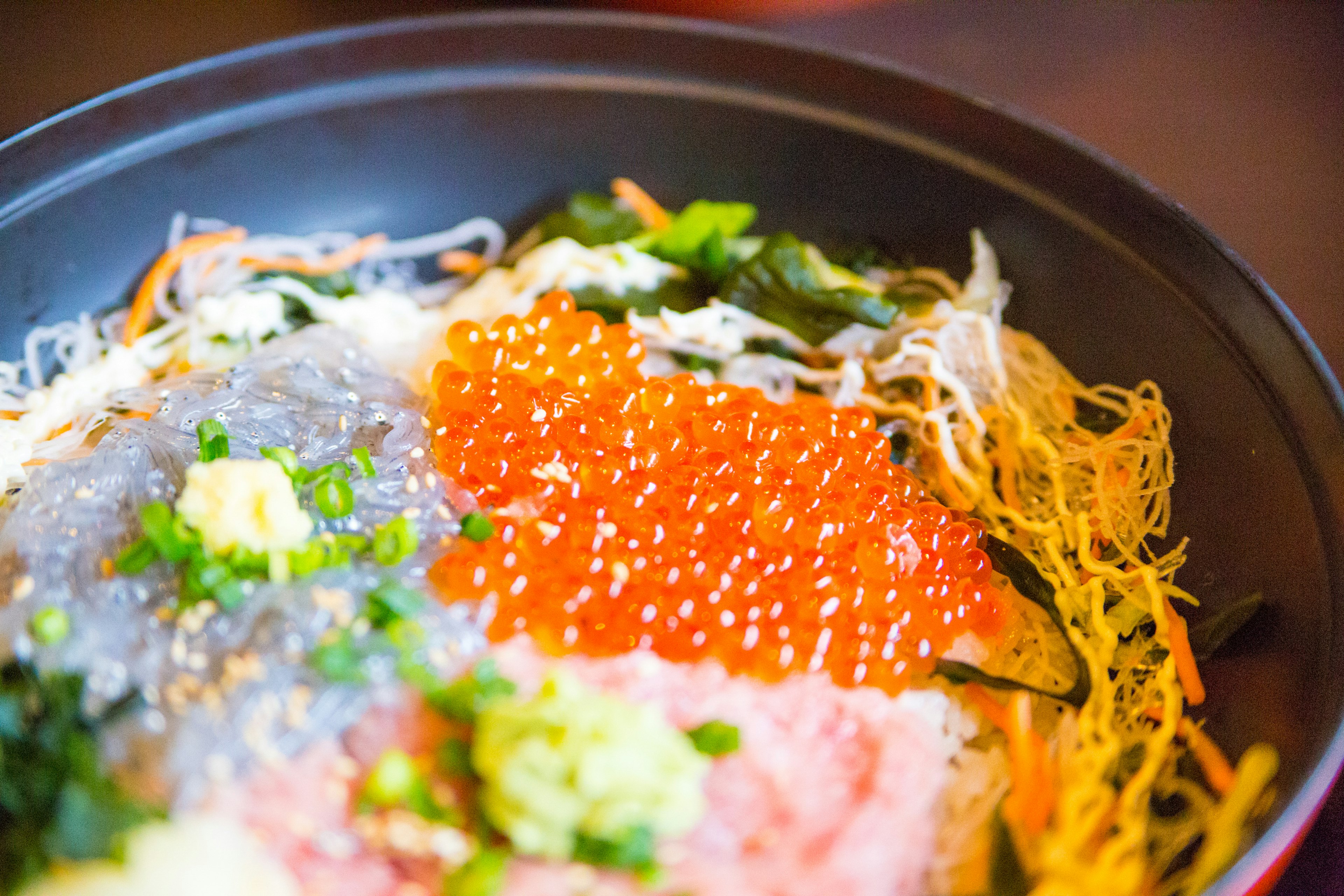 A seafood bowl featuring fresh sashimi and salmon roe