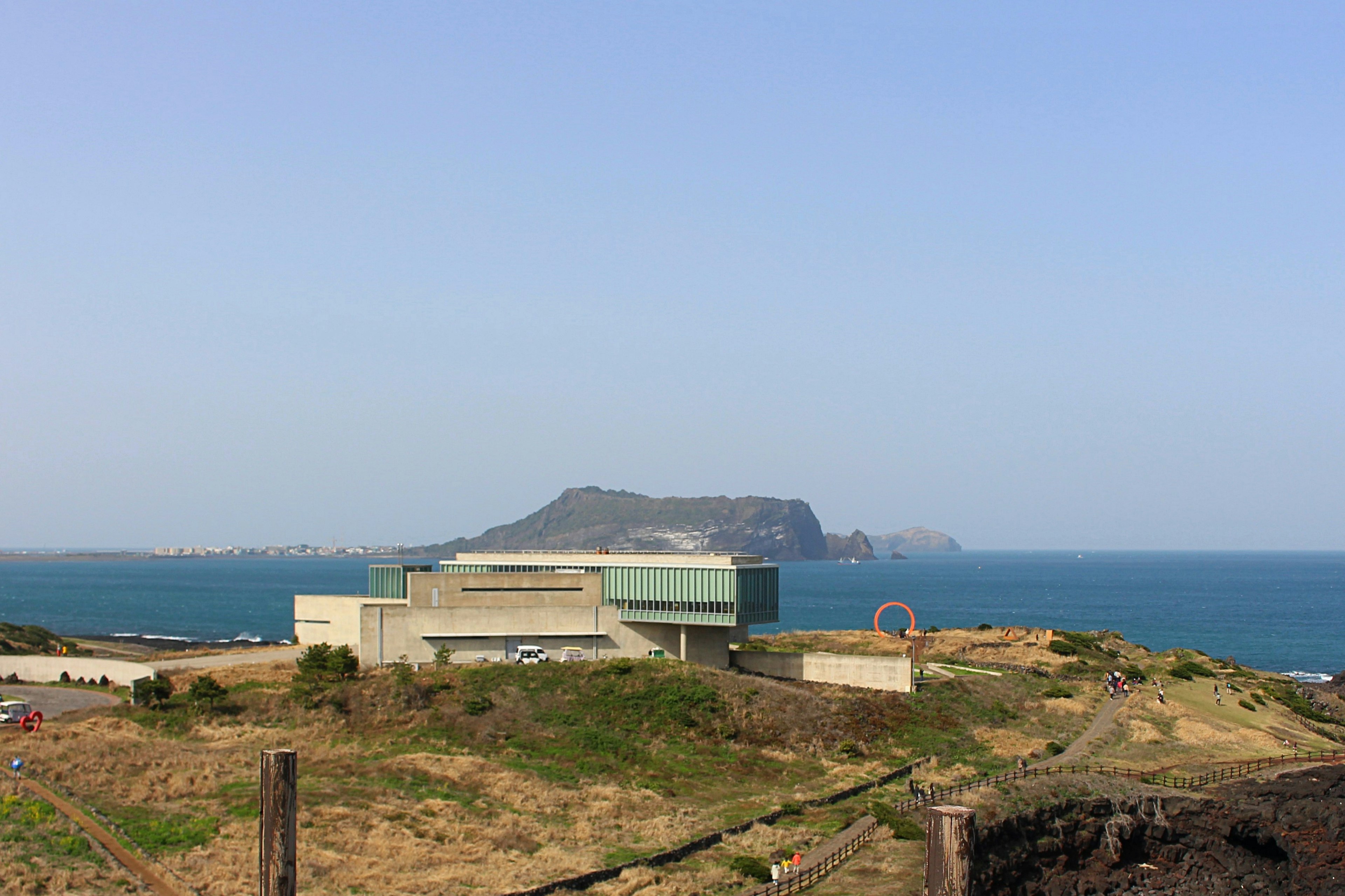 青い海と空を背景にした現代的な建物がある風景