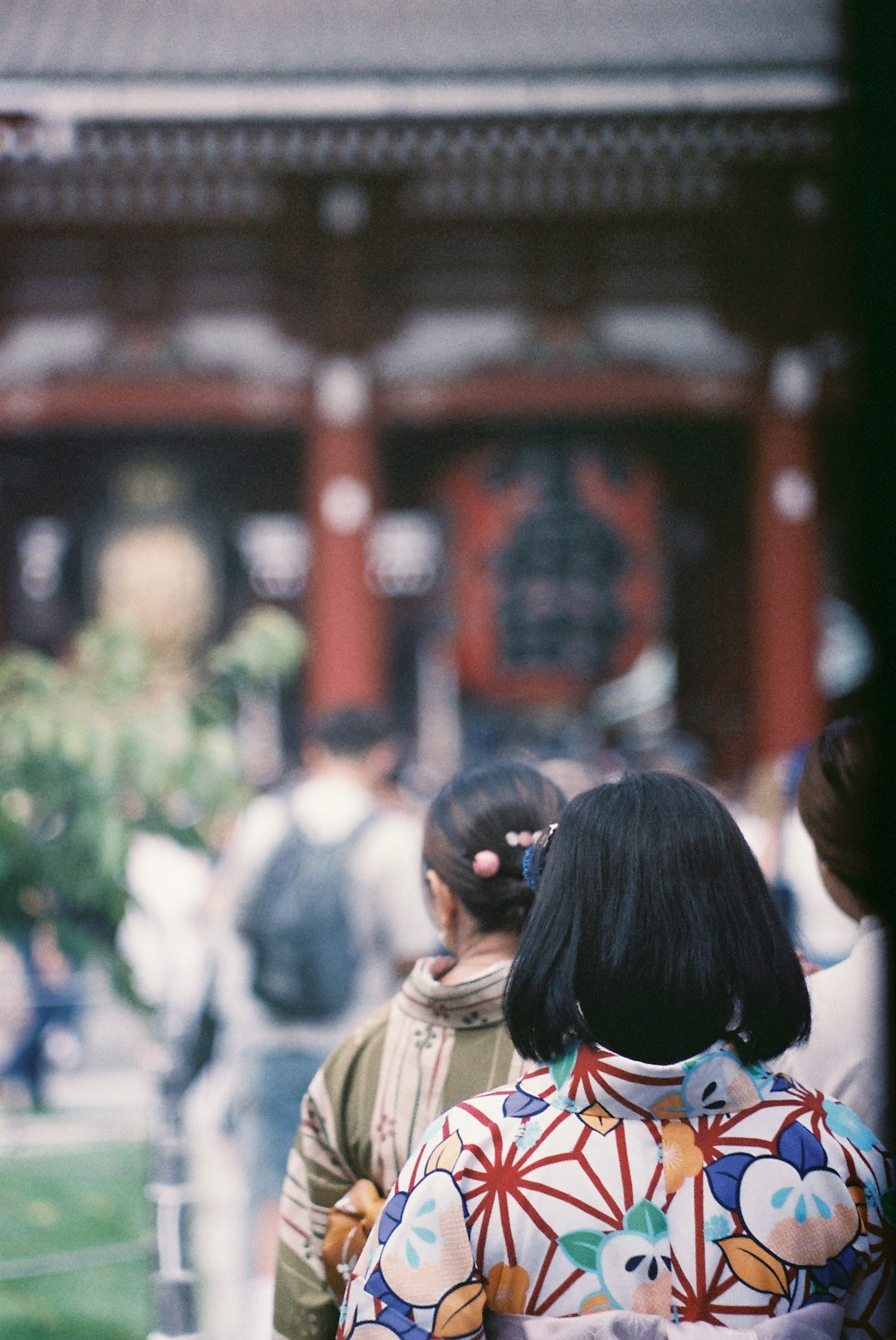 伝統的な着物を着た女性たちが神社の前で立っている風景