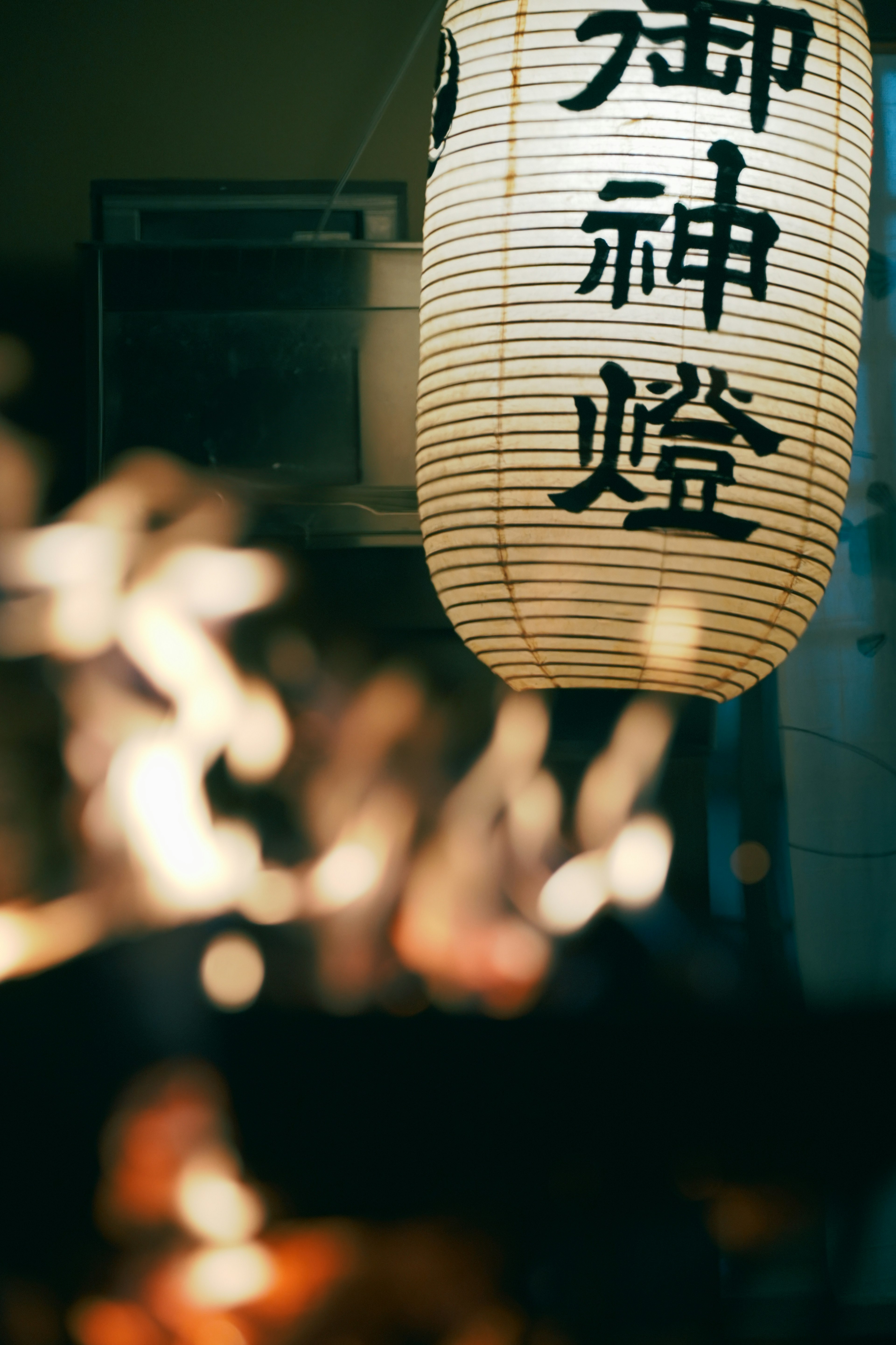 A traditional lantern illuminating a scene with a blurred flame in the background