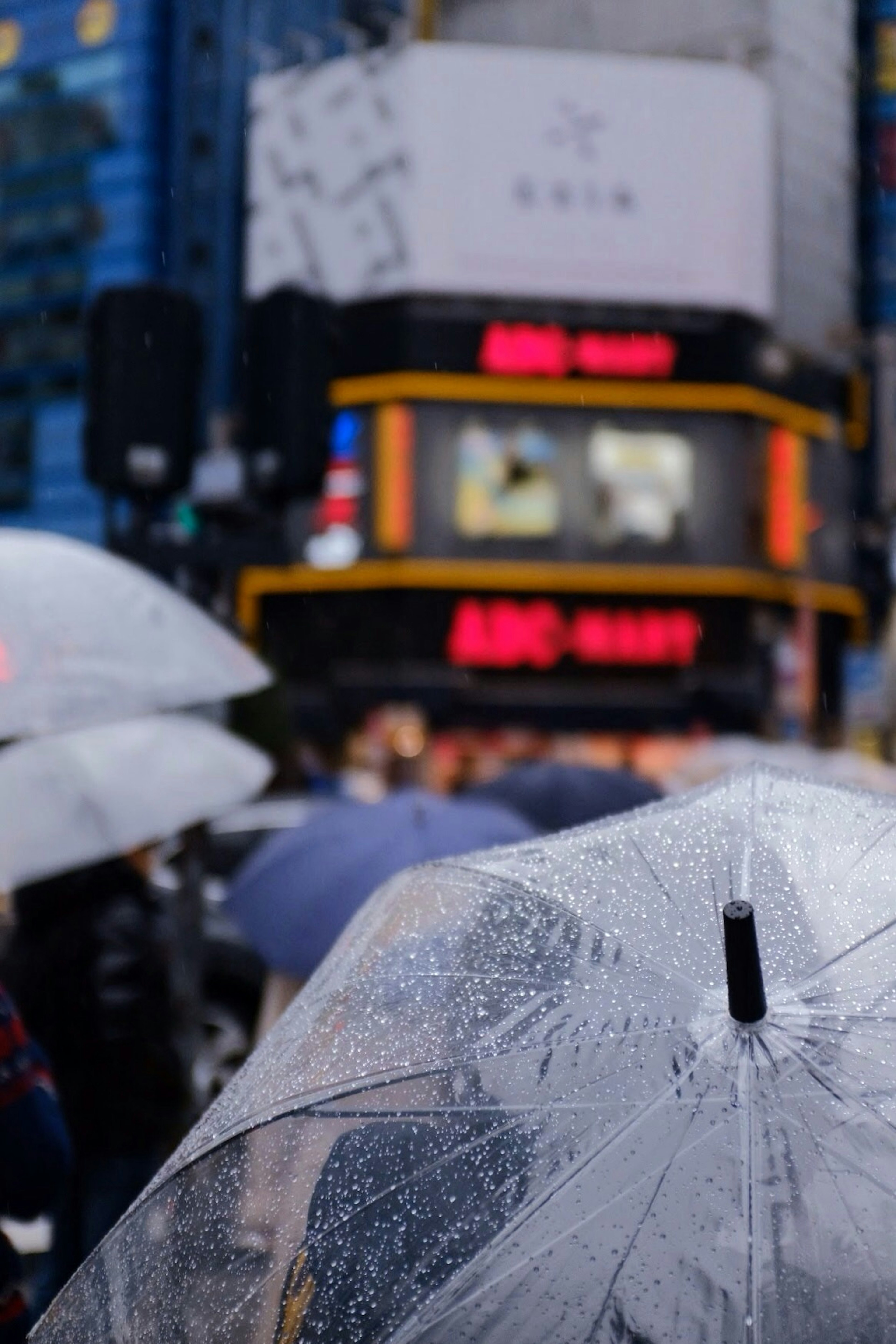 Regnerische Szene mit Regenschirmen und lebhaften Stadtlichtern