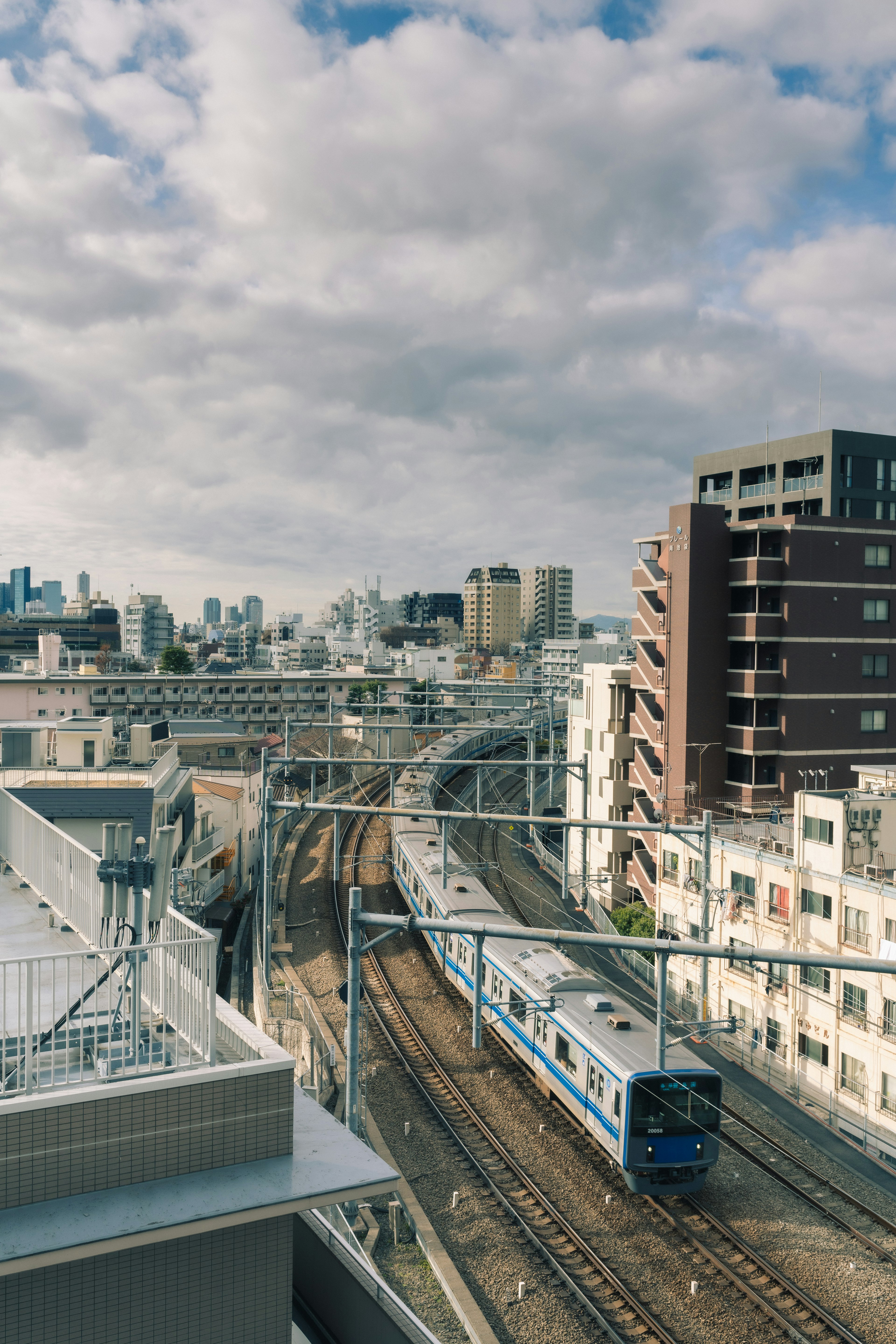 Urban railway scene featuring a train and surrounding buildings