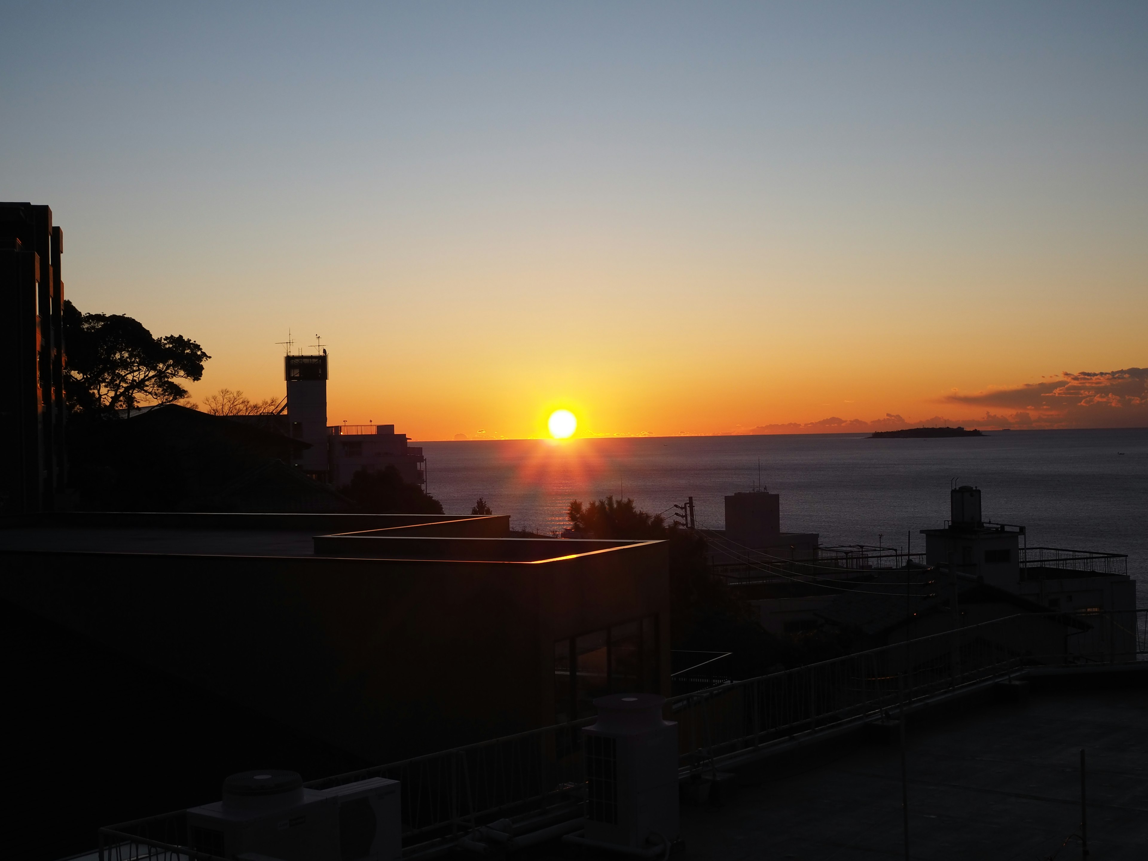 夕日が海に沈む風景 建物のシルエットが美しい