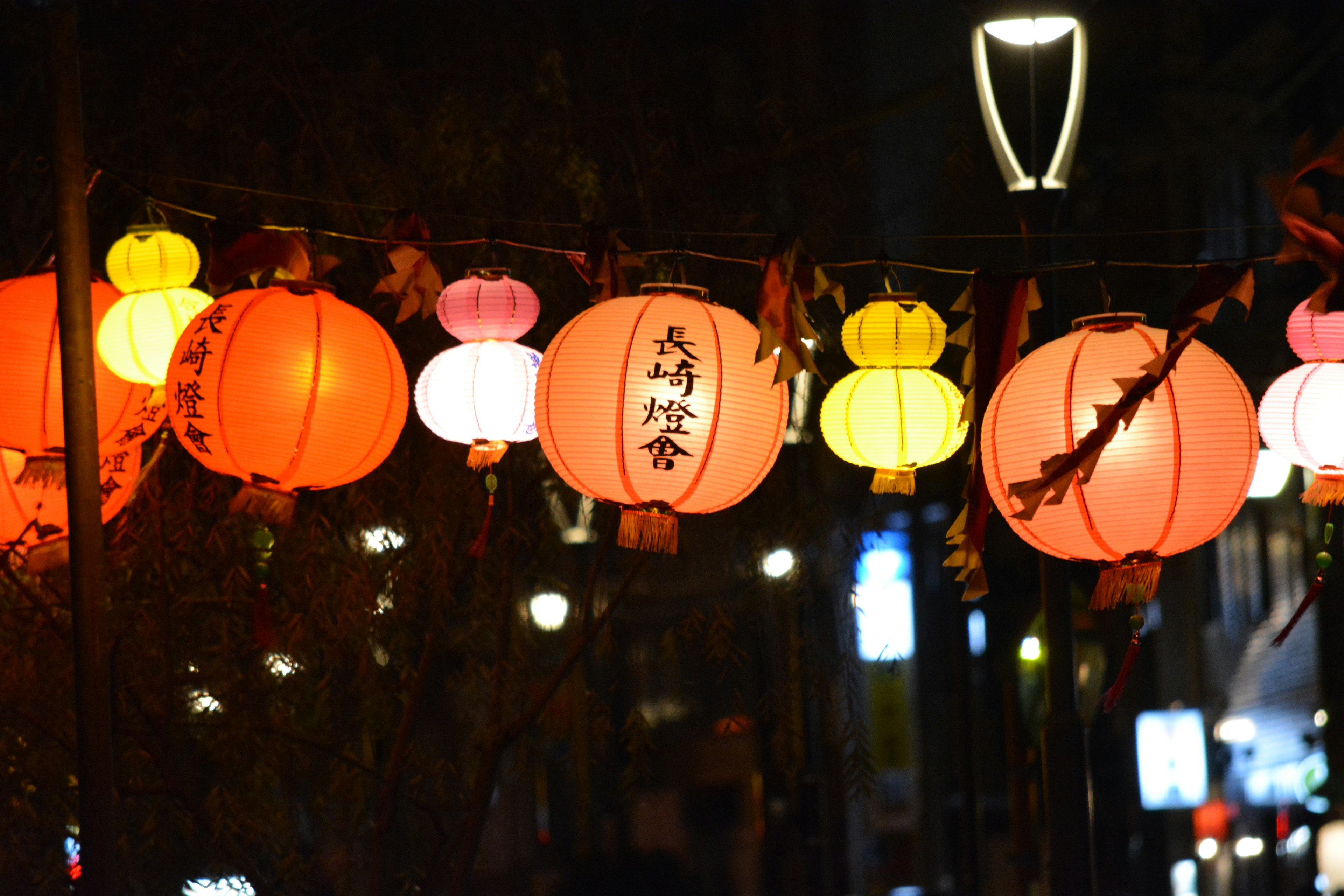 Des lanternes colorées suspendues dans une rue nocturne