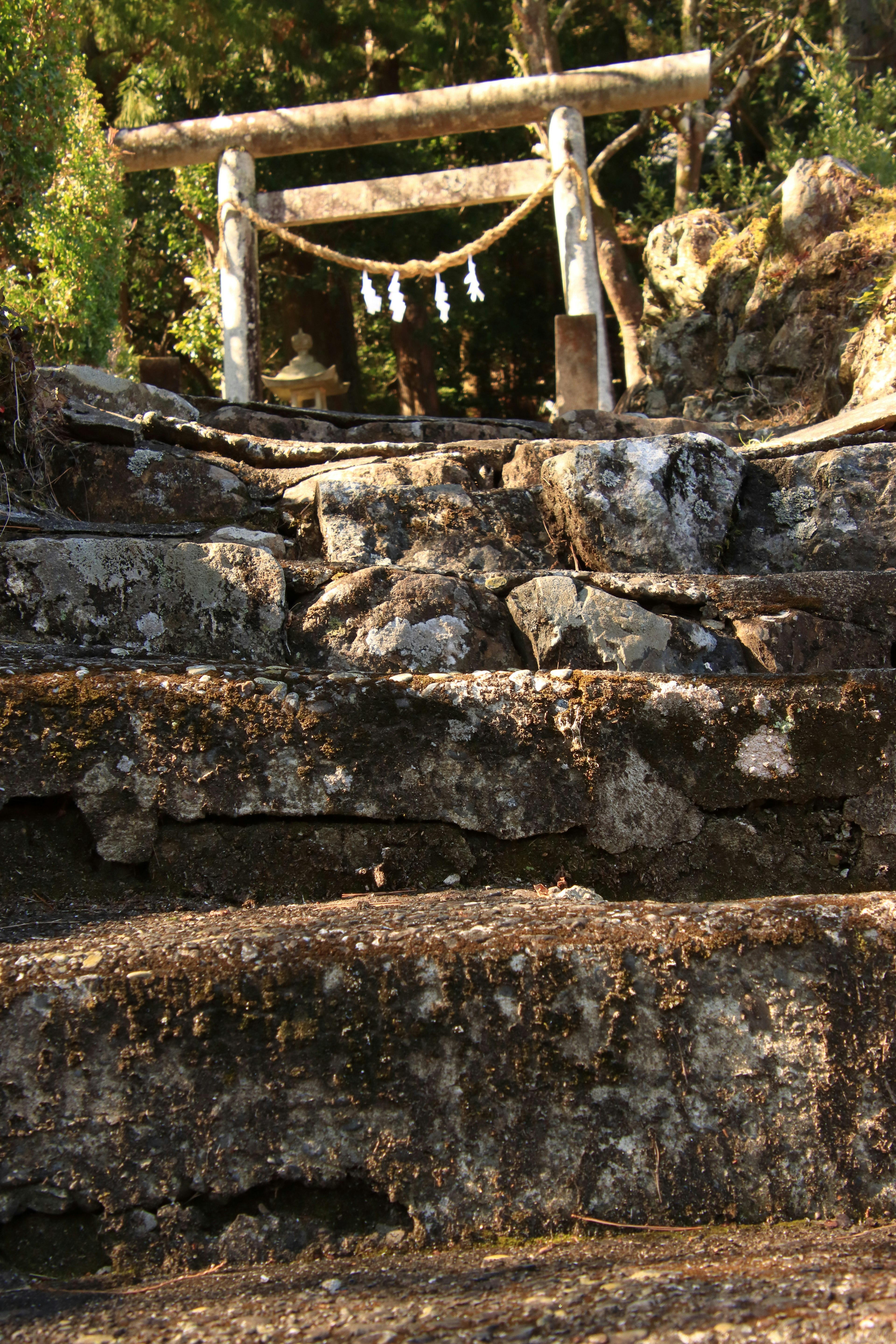 Gerbang torii dengan dekorasi menggantung di tangga batu