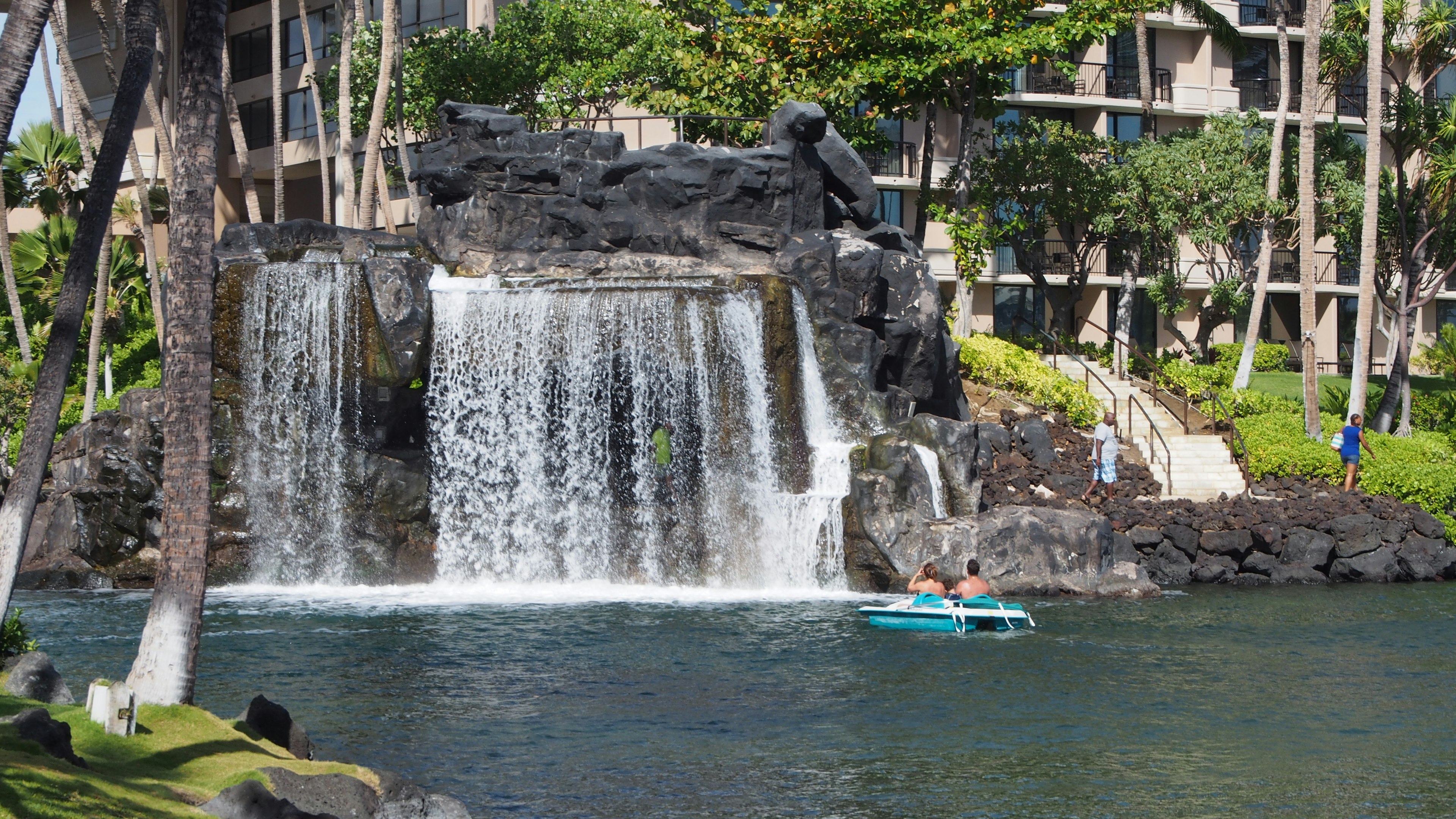 Tropical scene featuring a beautiful waterfall and a blue kayak