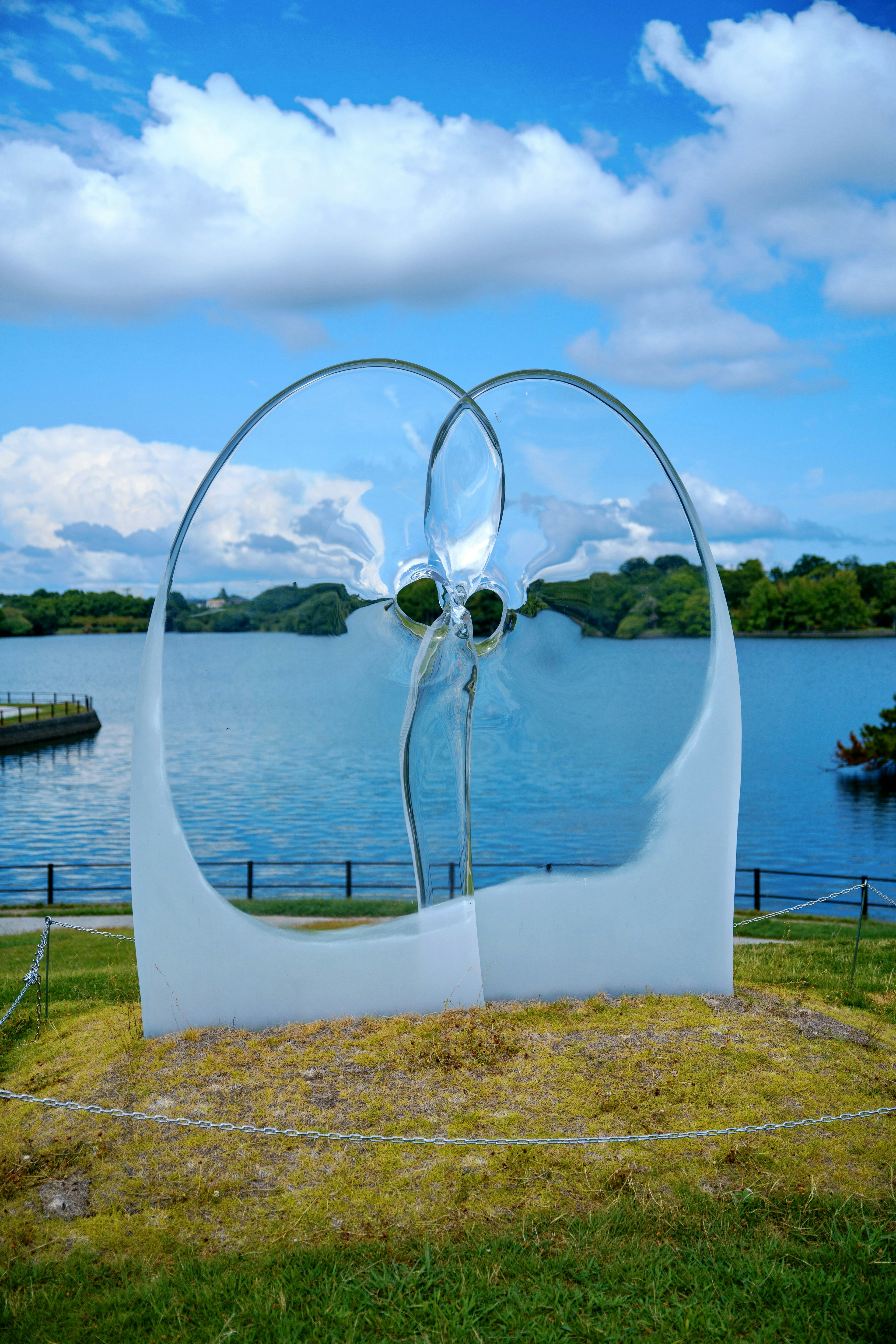 Weiße Skulptur, die zwei Gesichter nahe einem See bildet