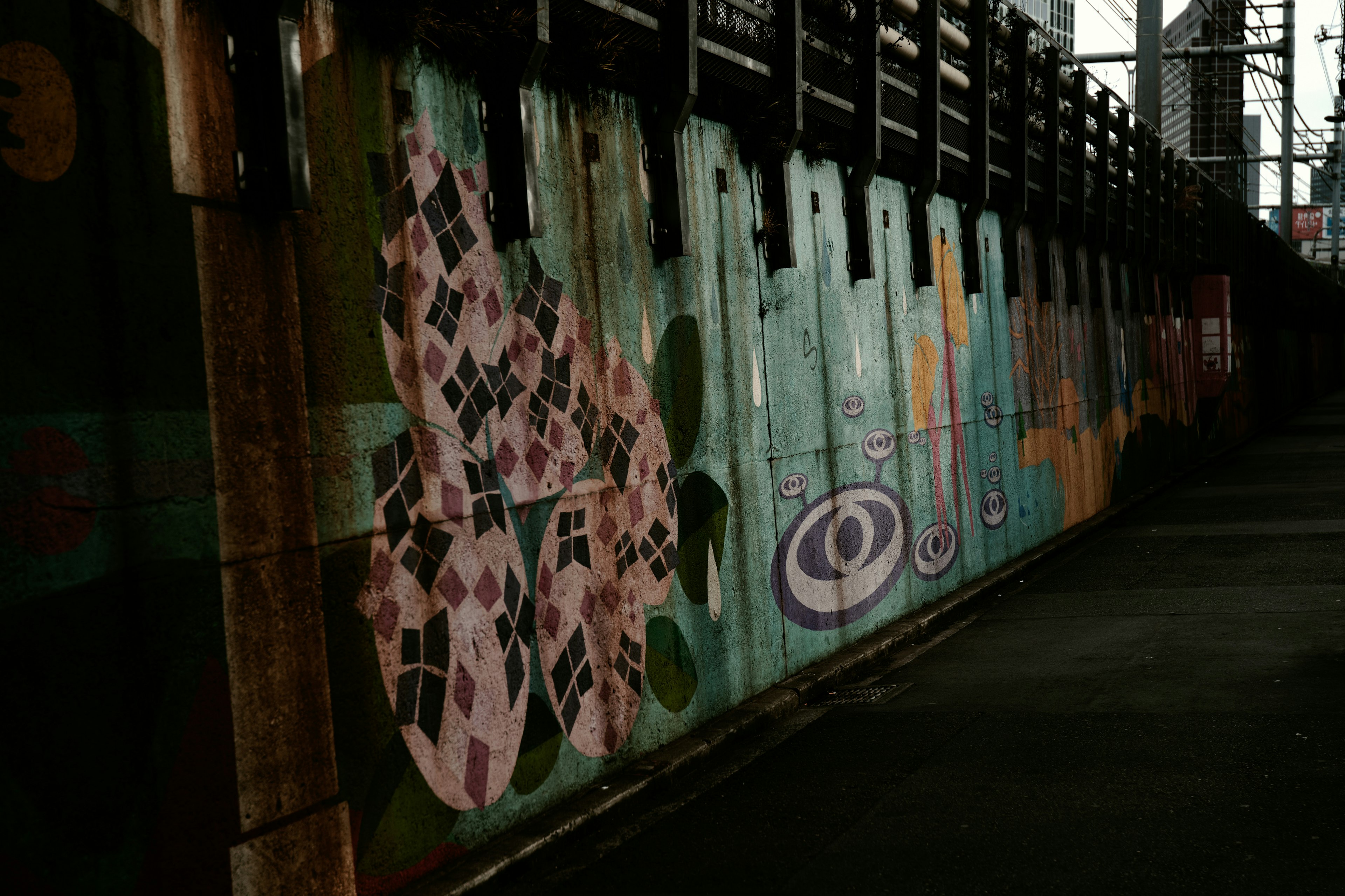 Murales colorati su un muro con uno sfondo scuro