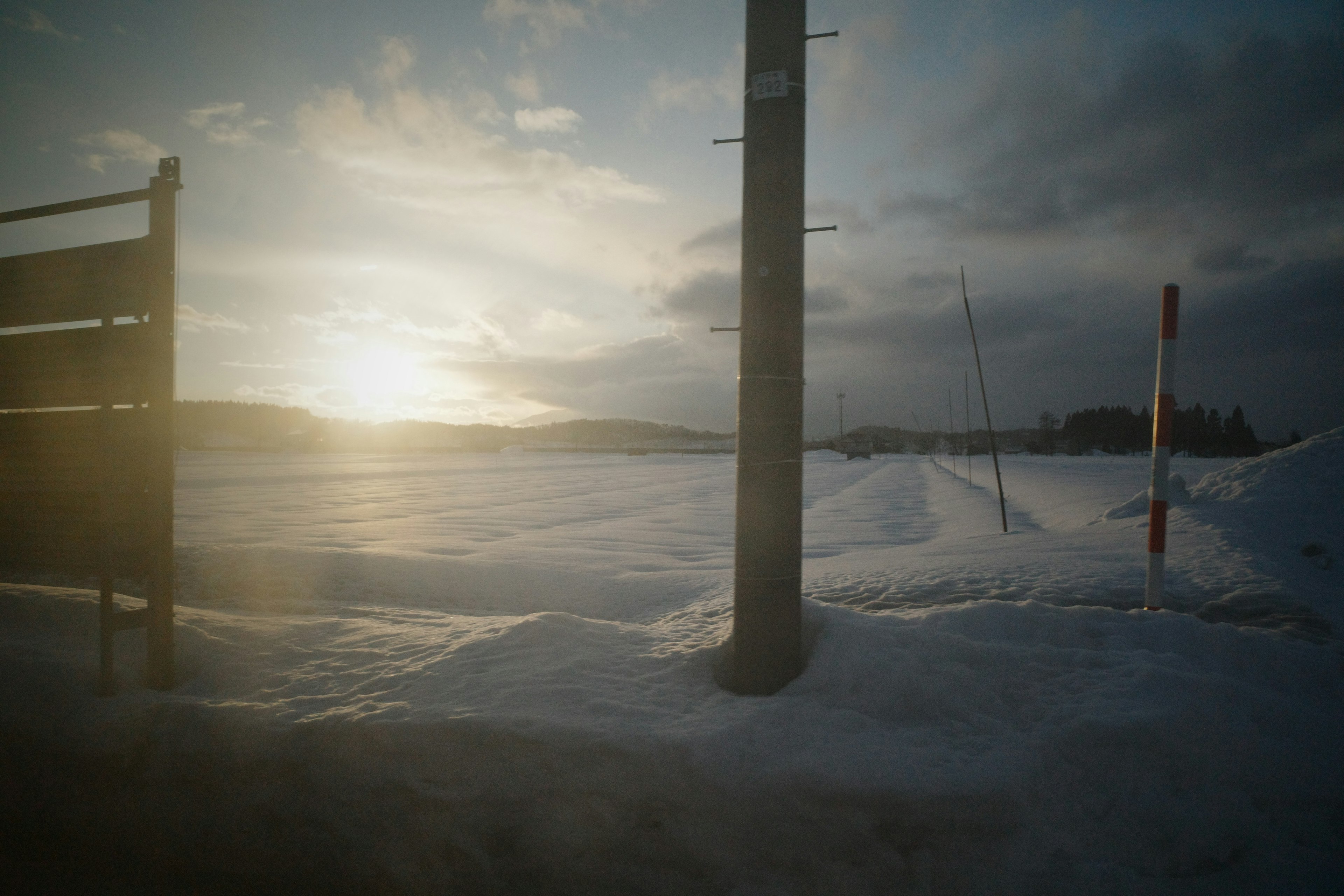 雪に覆われた風景と夕日のシルエット