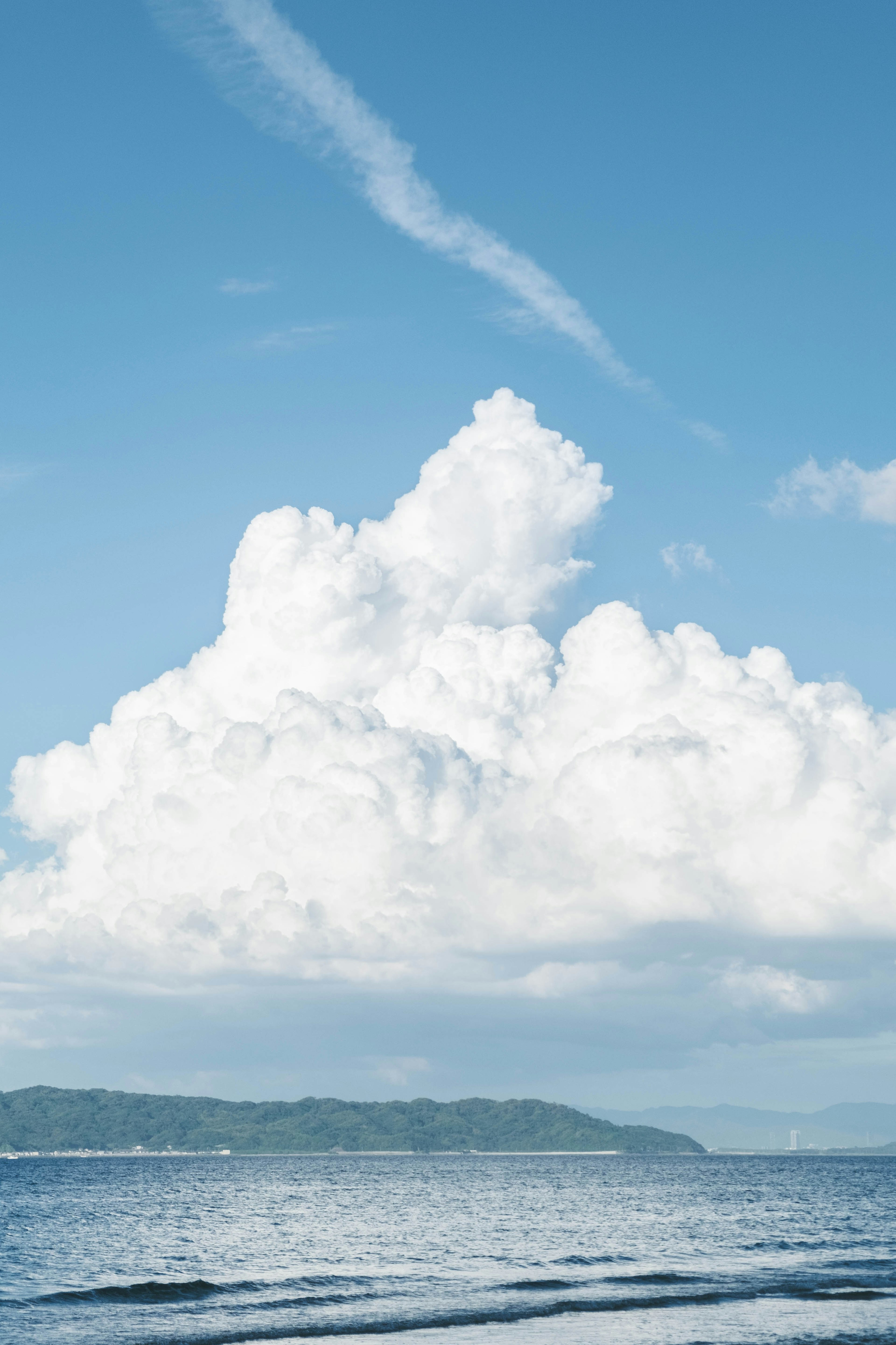 青い空と白い雲が広がる海の風景