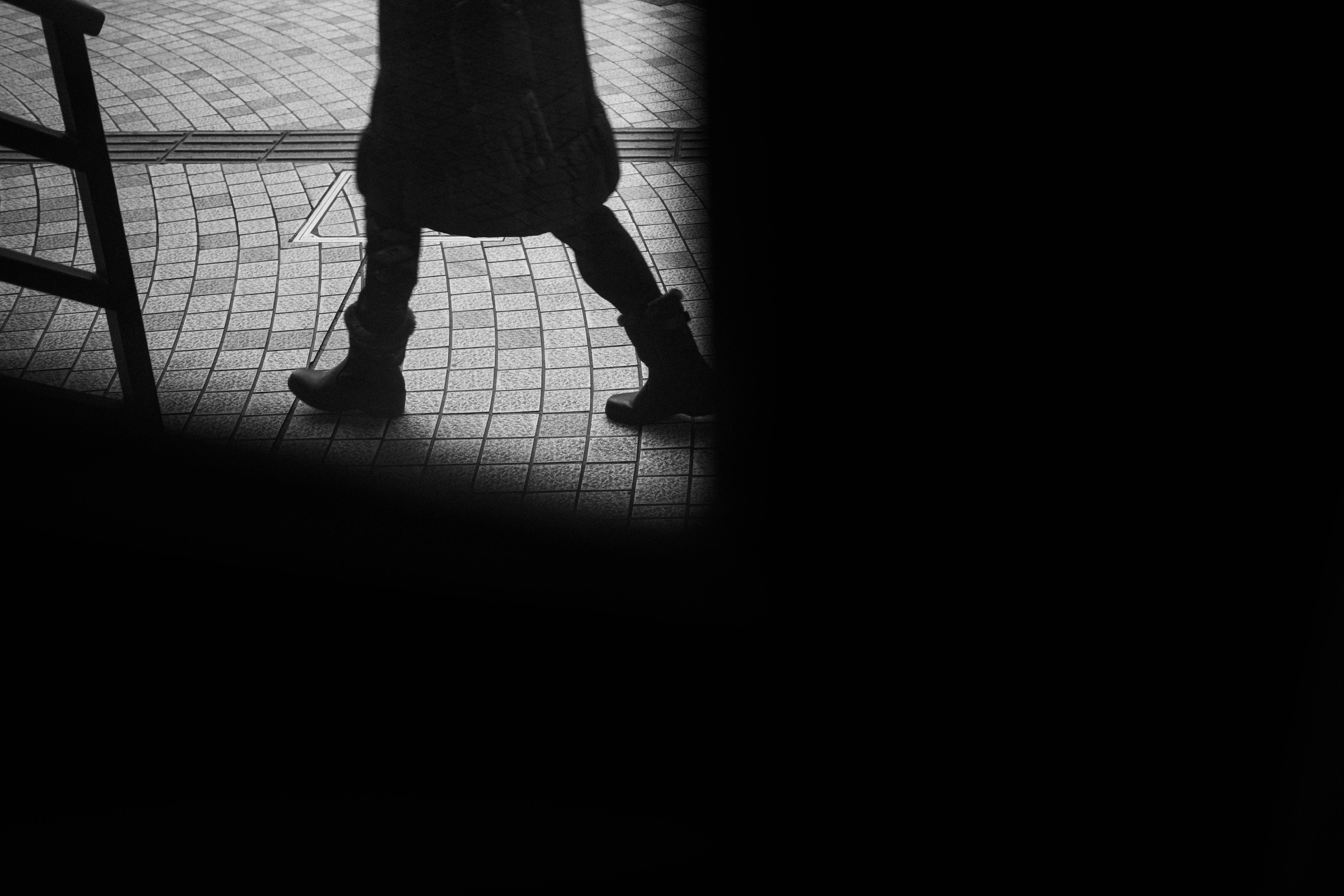 Imagen que muestra los pies de una persona caminando en blanco y negro