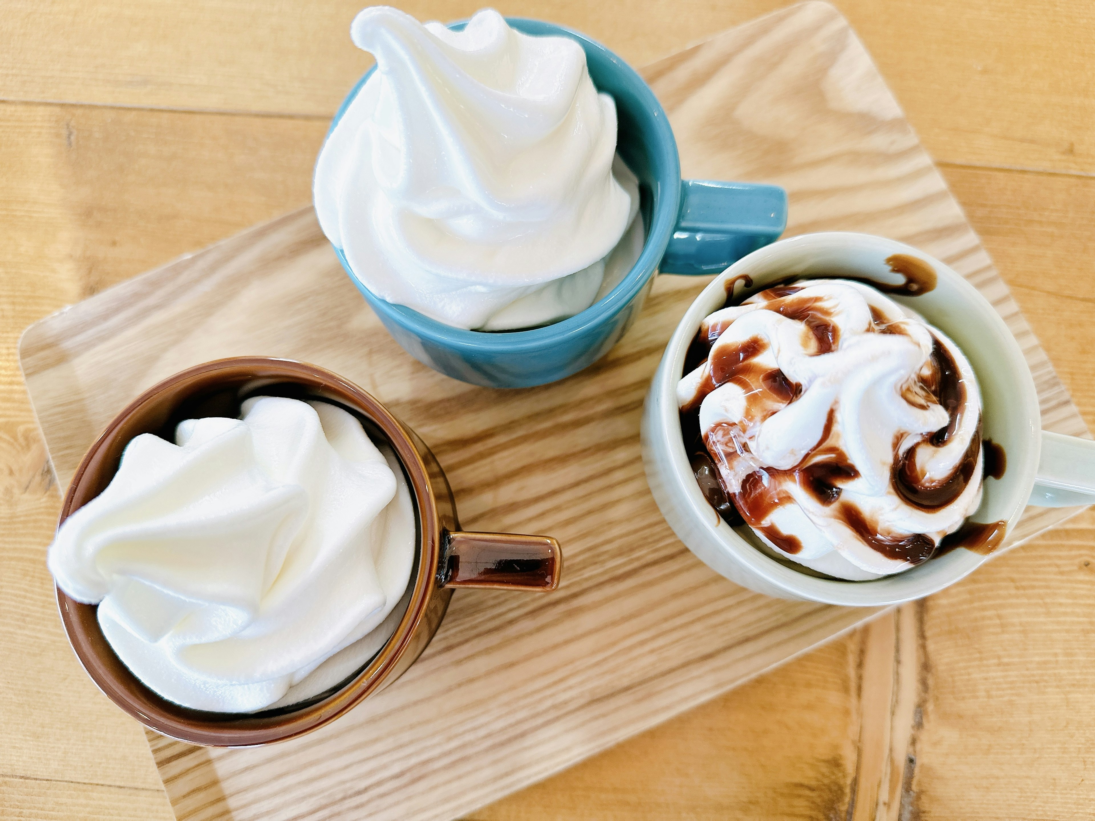 Tres tazas llenas de postres con crema batida