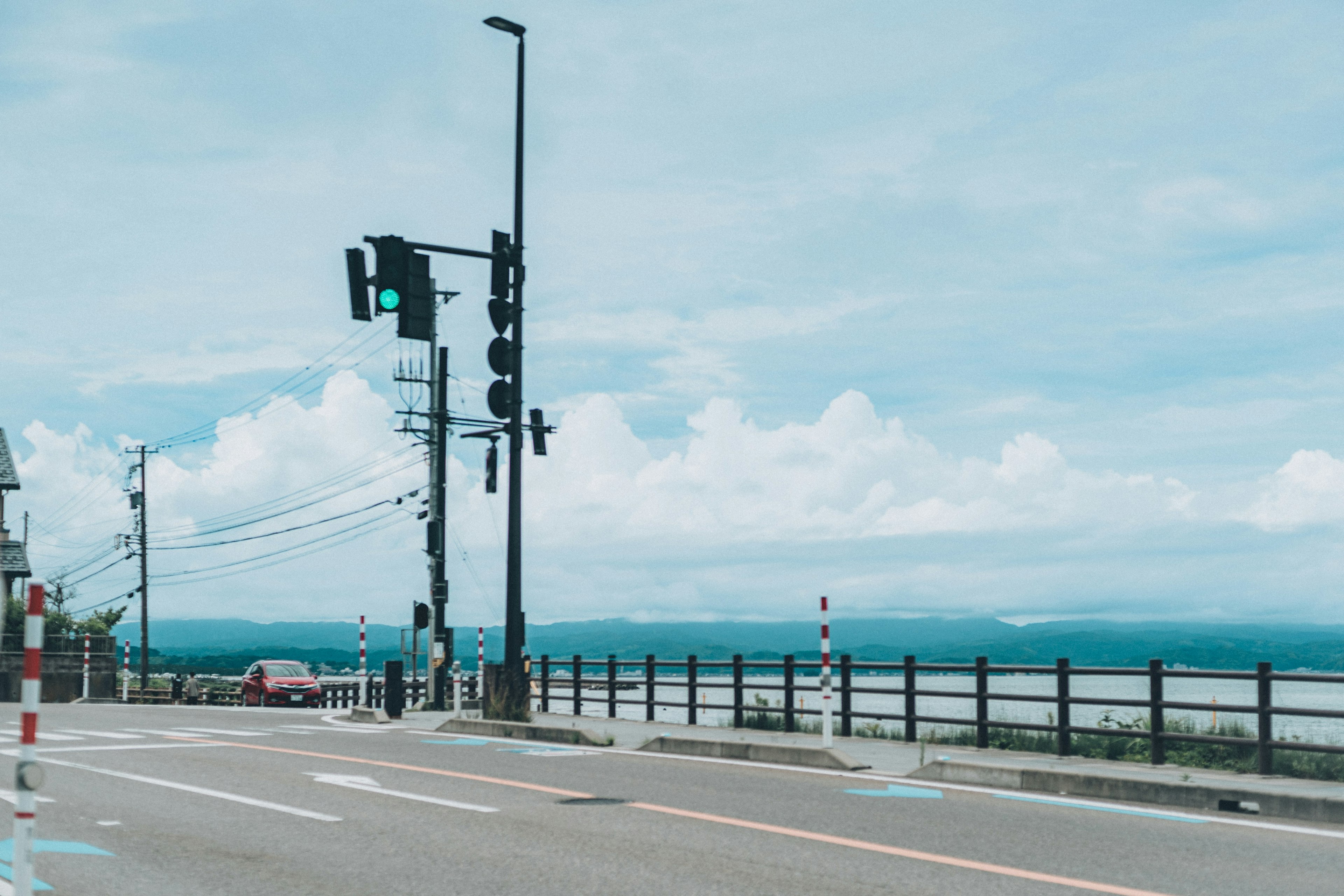 สัญญาณไฟจราจรและถนนใต้ท้องฟ้าสีฟ้าพร้อมเมฆขาว