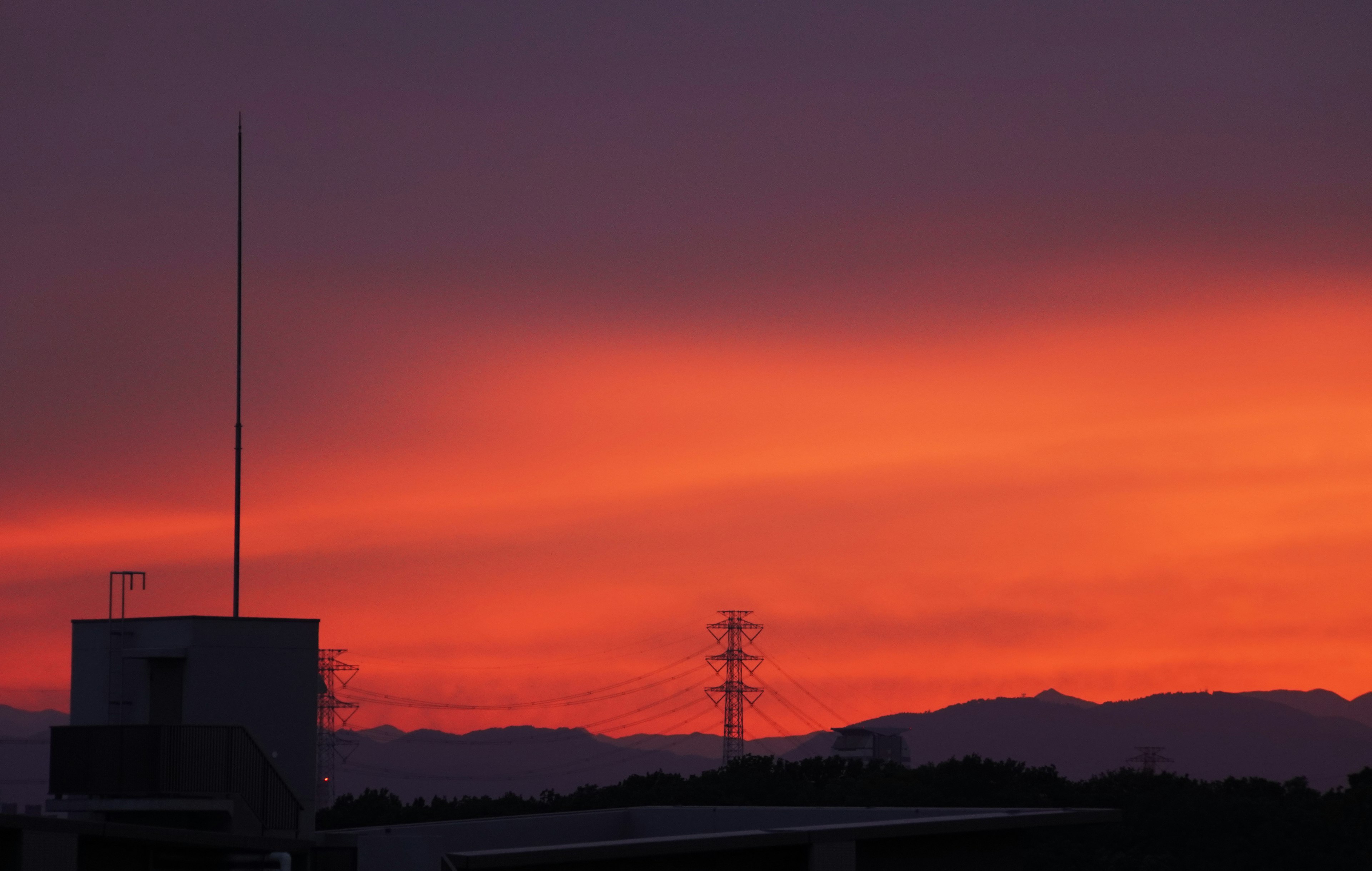 Sonnenuntergangshimmel mit lebhaften orange und lila Farbtönen über Bergen