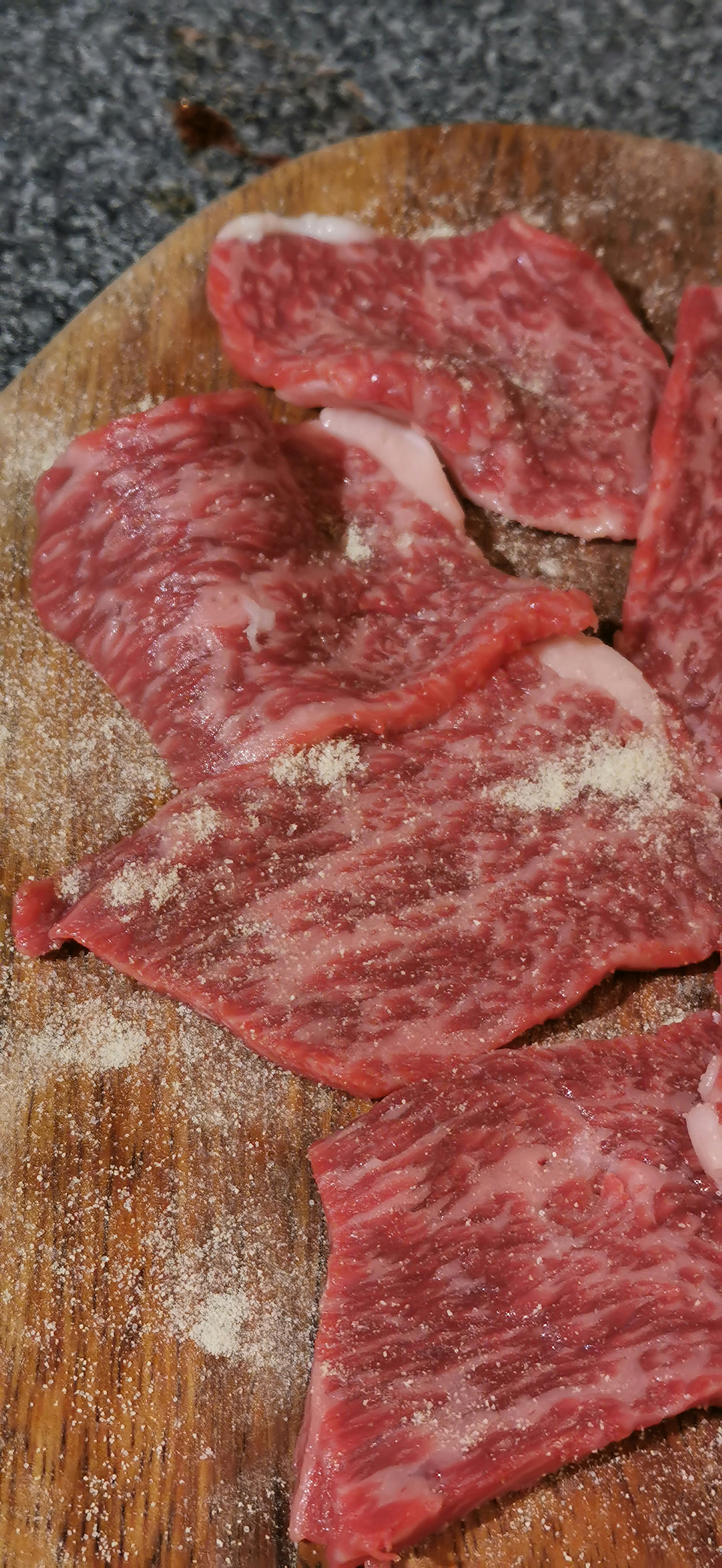 Slices of marbled beef on a wooden cutting board