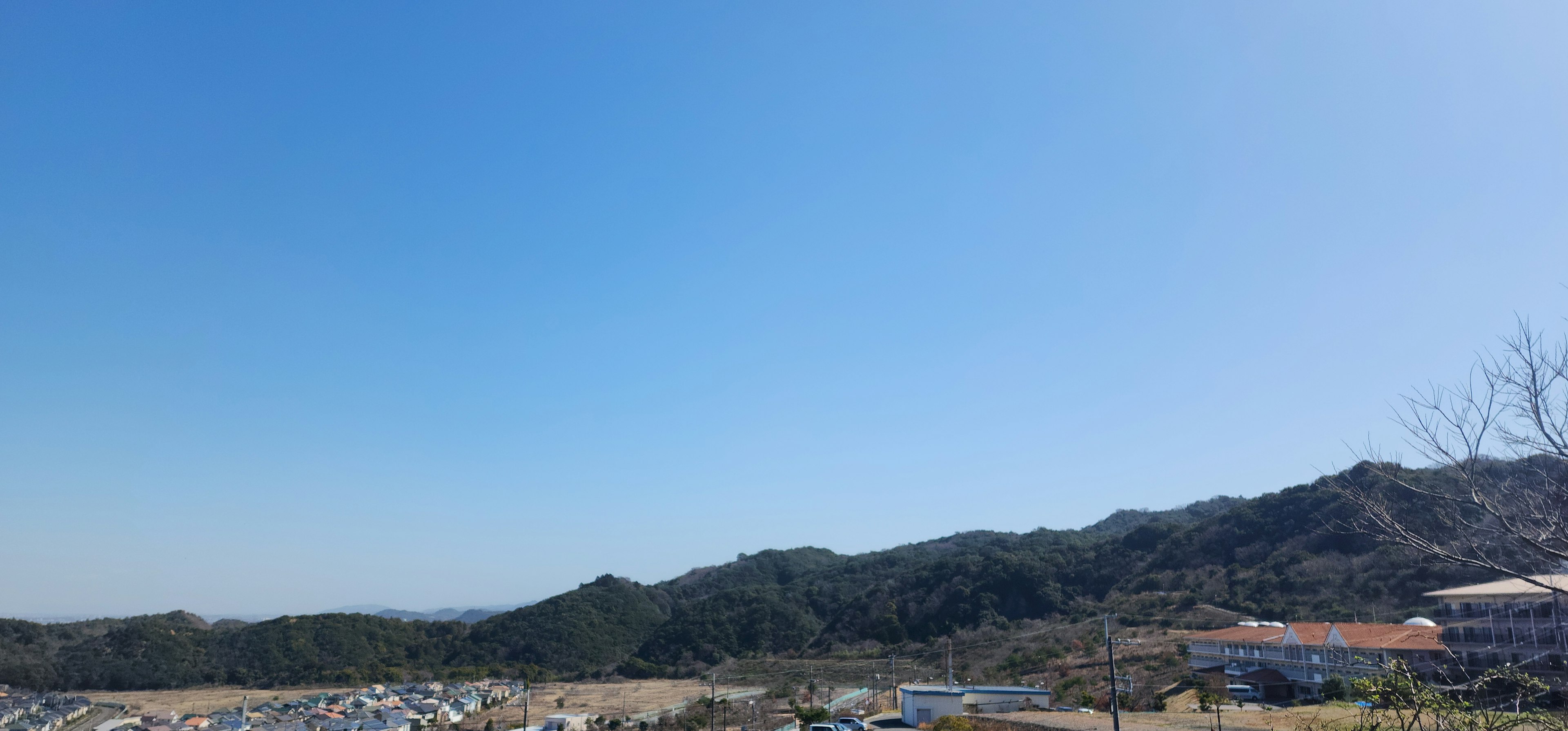 Un paysage avec un ciel bleu clair et des collines vertes