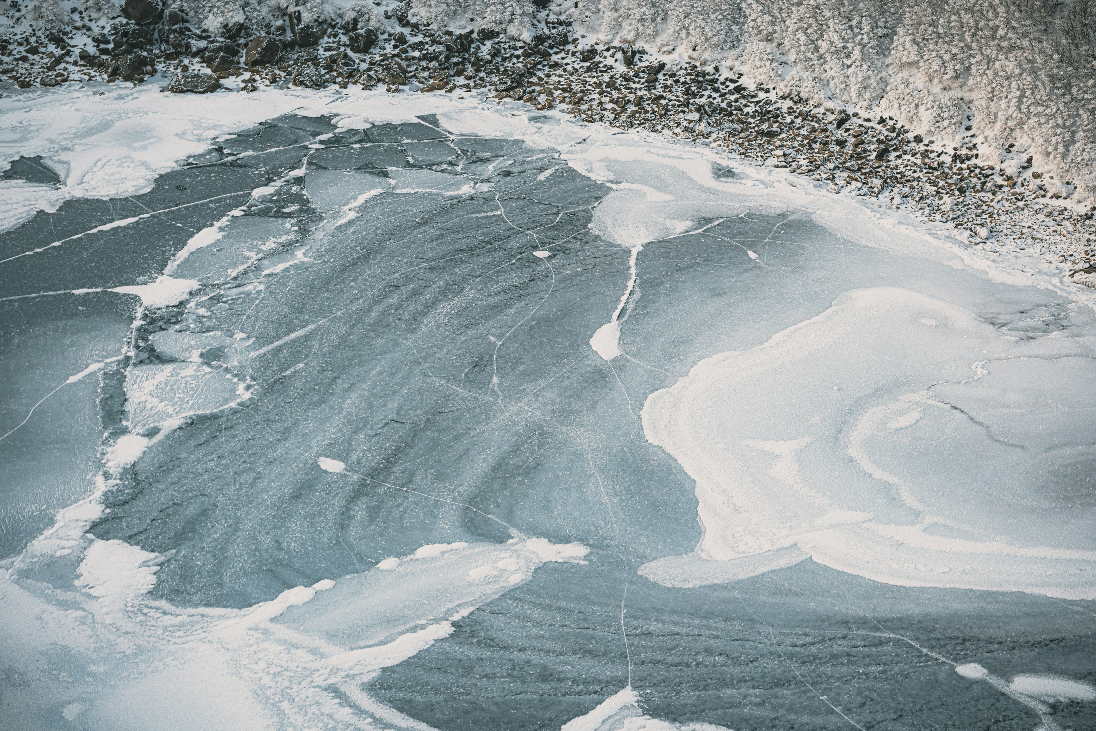 Patrones de superficie de agua azul con espuma blanca sobre hielo