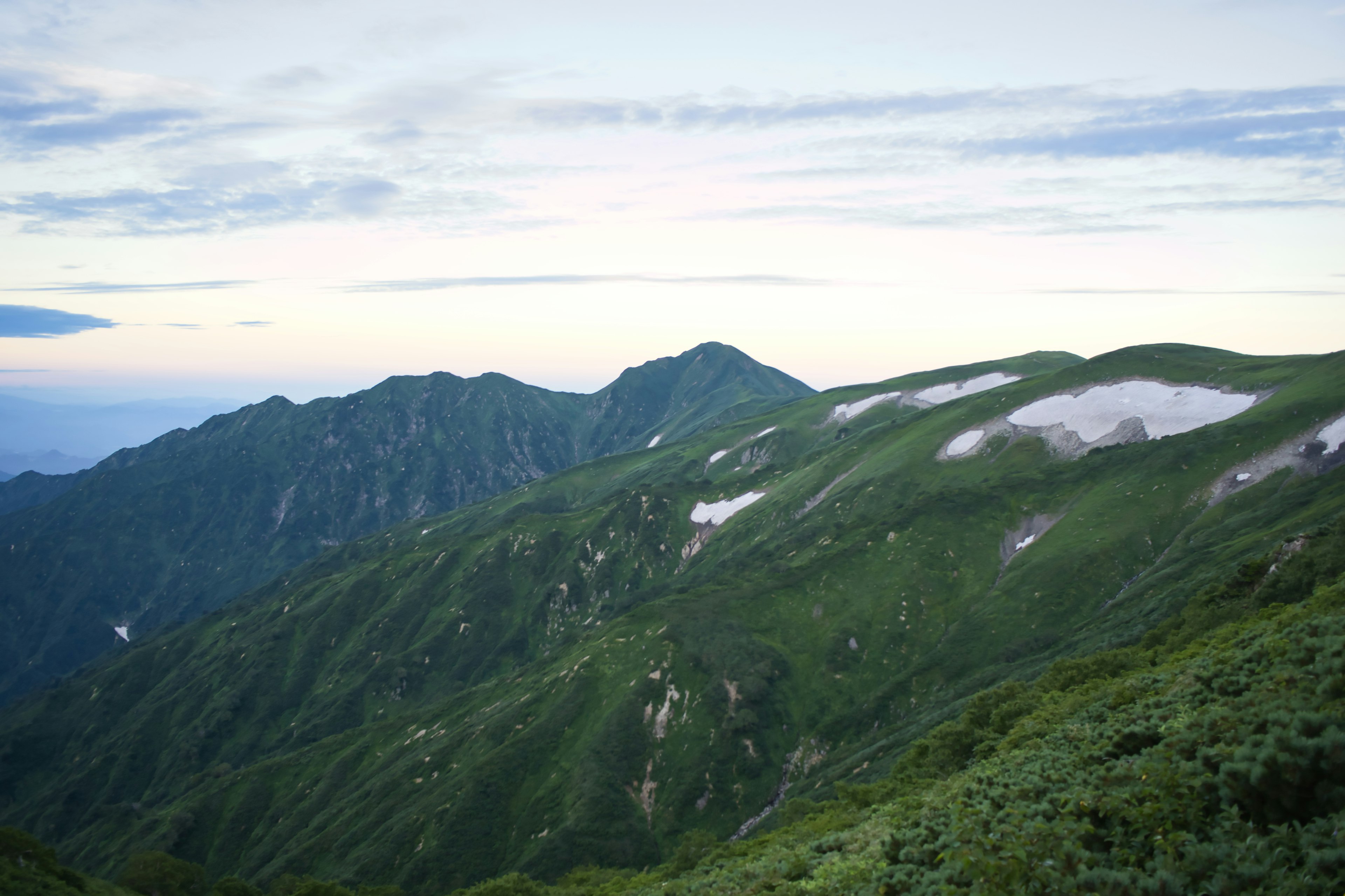 Üppige grüne Berge mit einem ruhigen Himmel