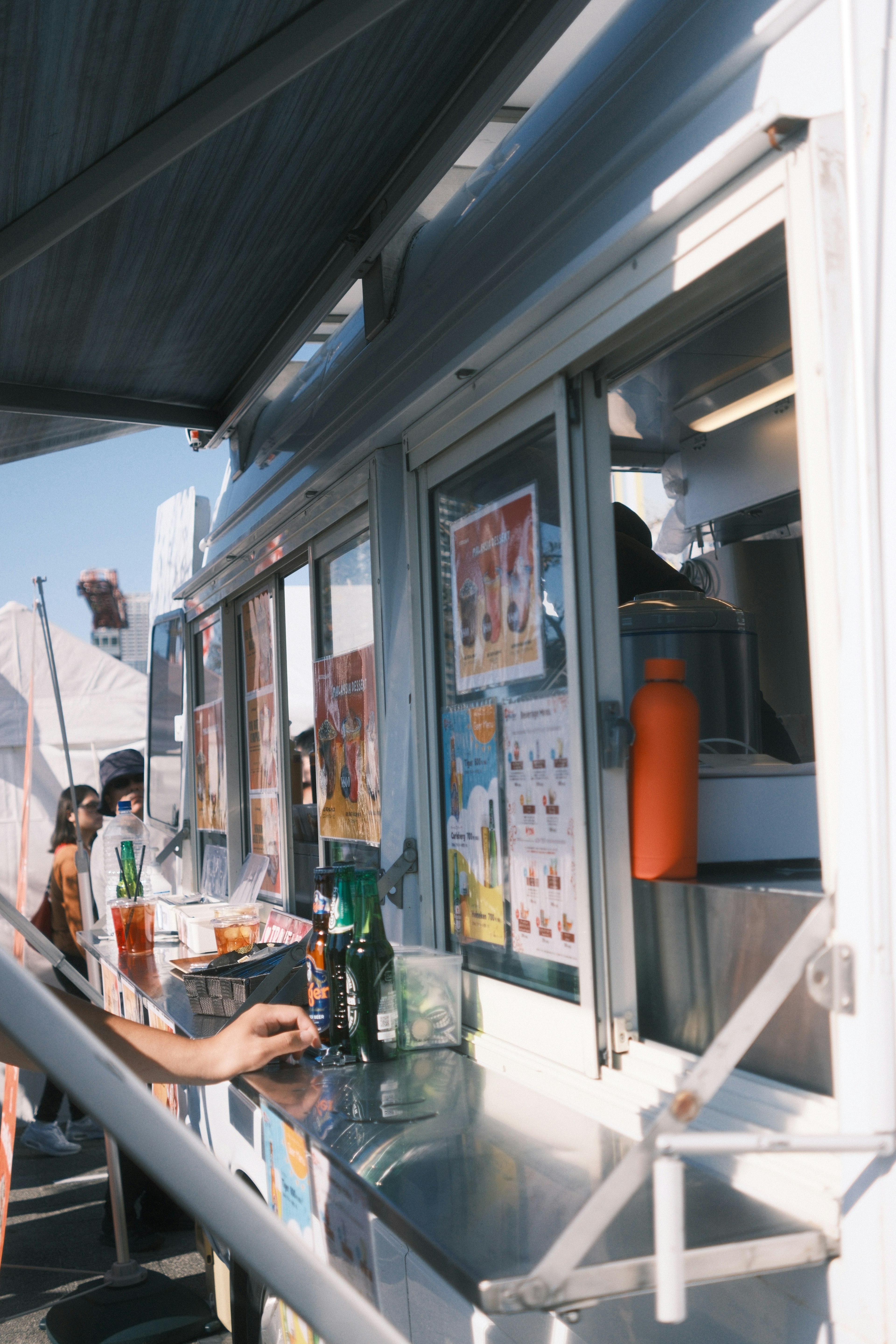 Una persona pidiendo bebidas en la ventana de un camión de comida