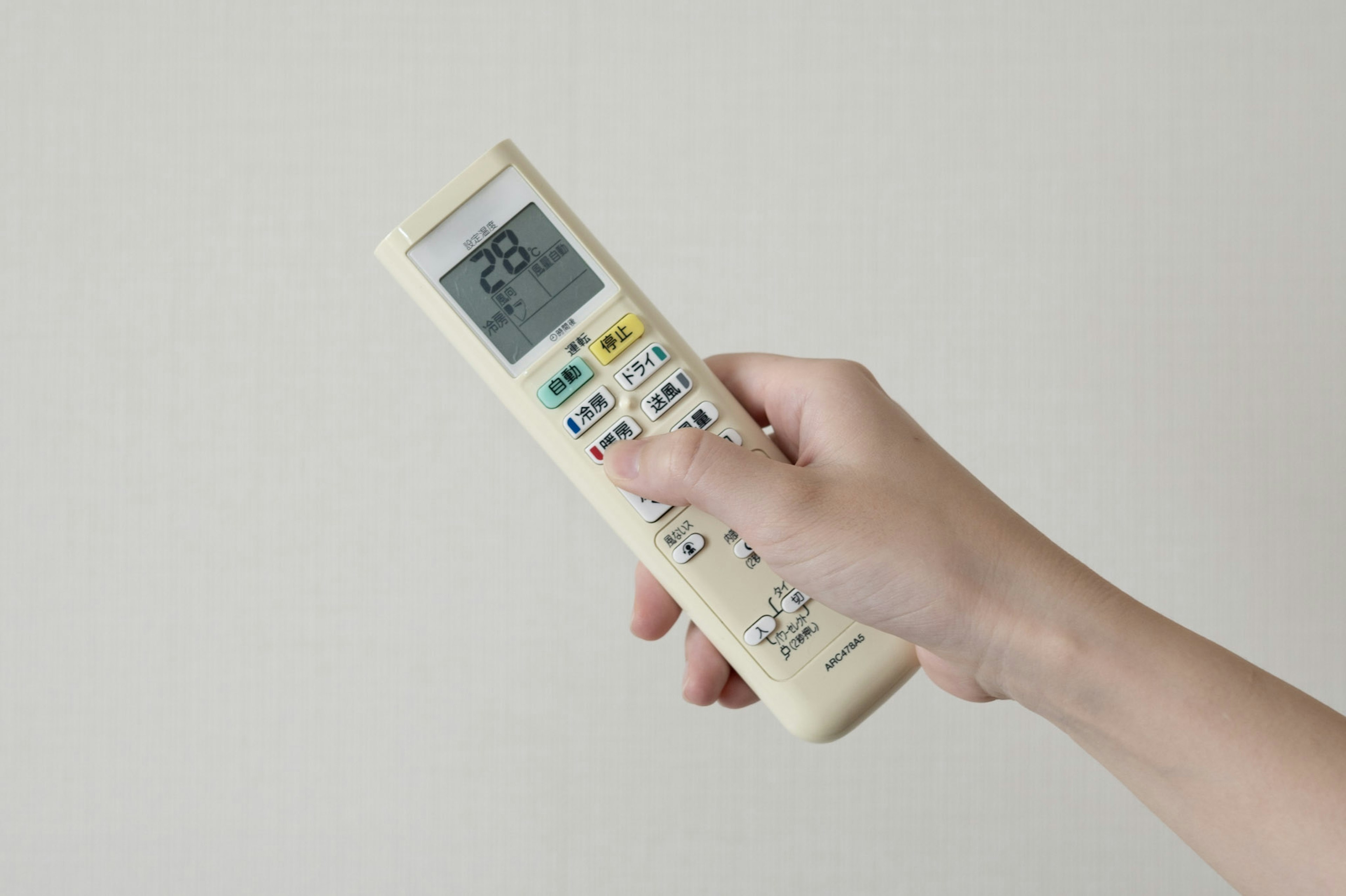 Hand holding a remote control White background Temperature display