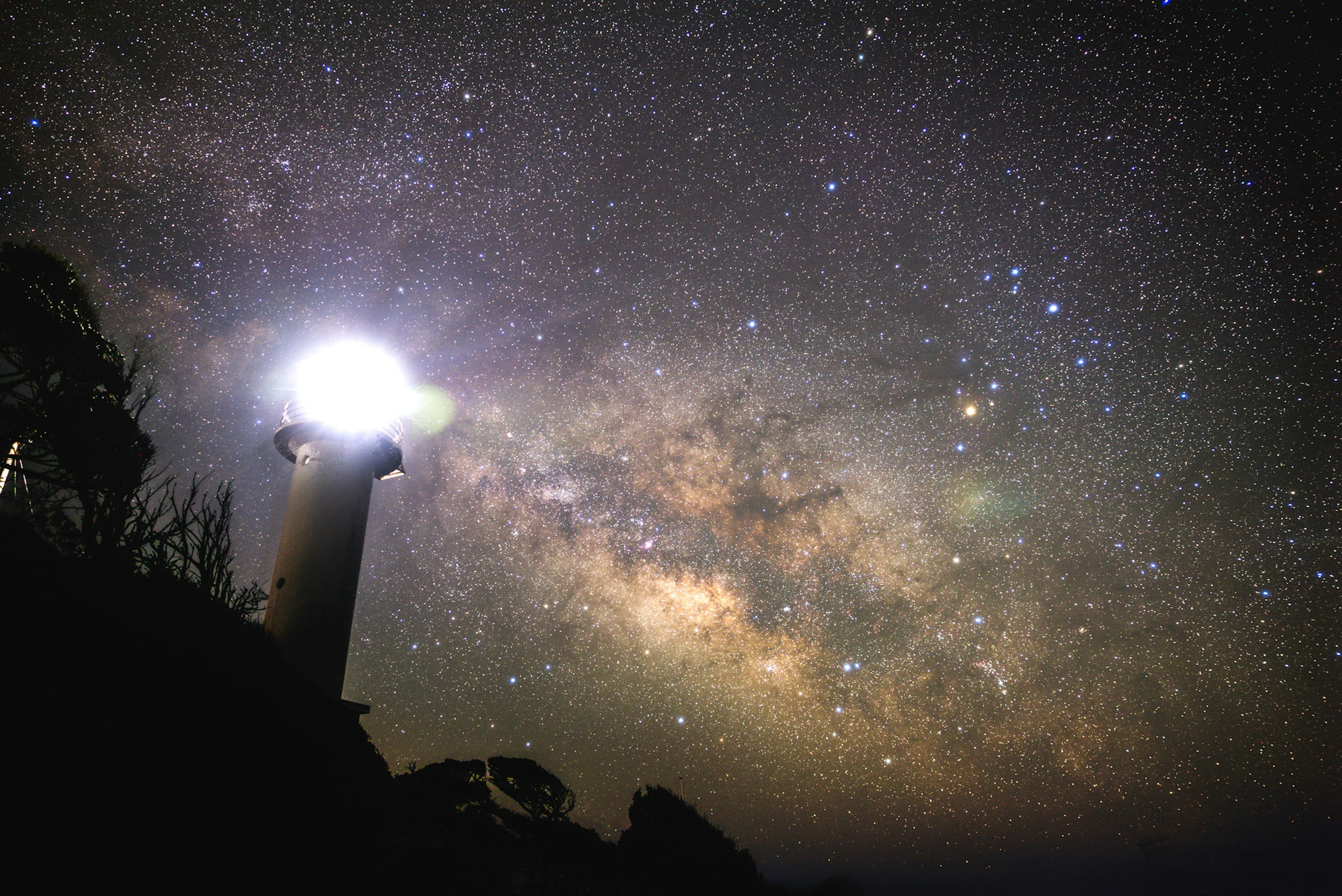 灯台と満天の星空が広がる美しい風景