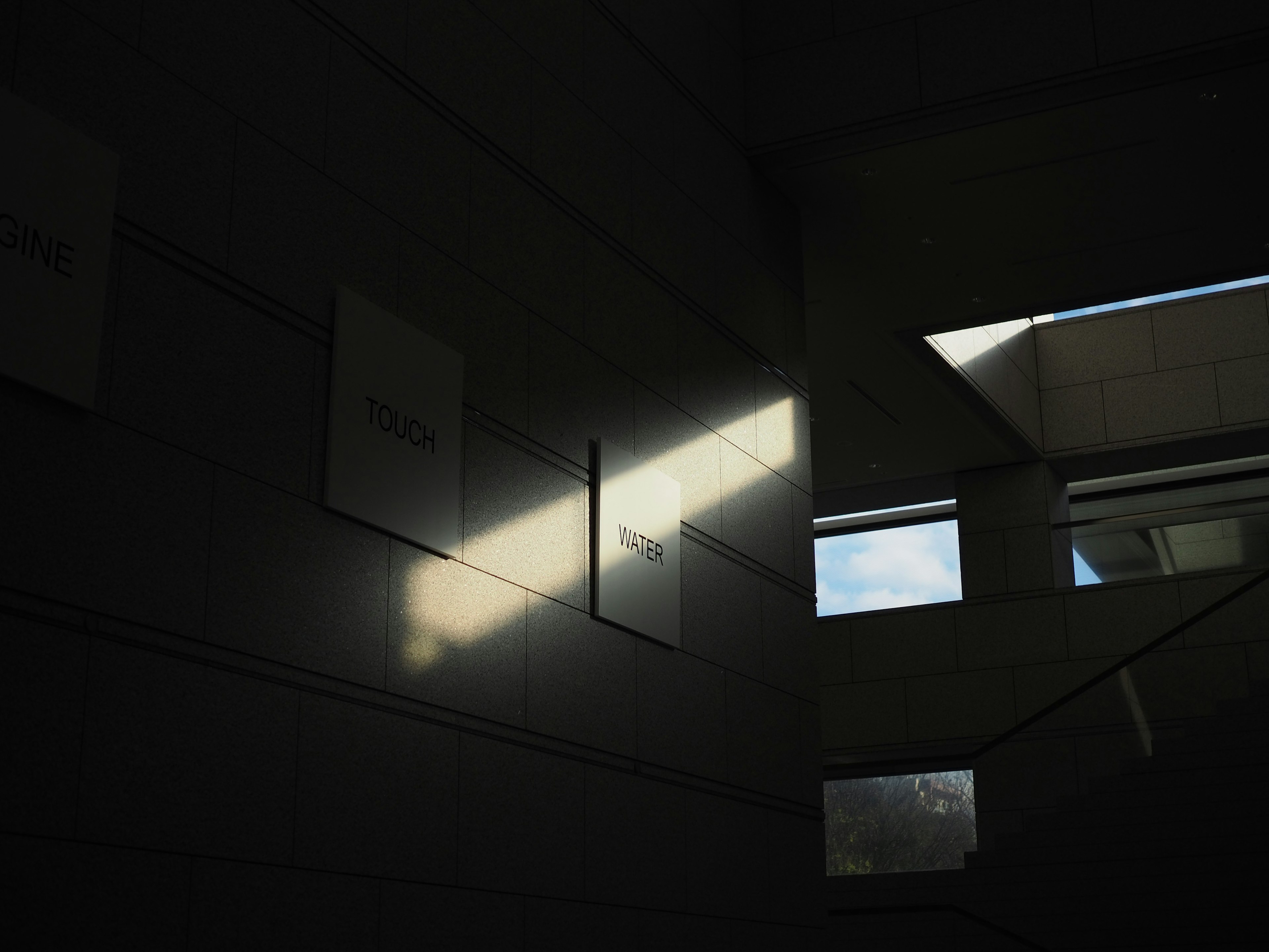 Interior space featuring a beam of light and geometric windows