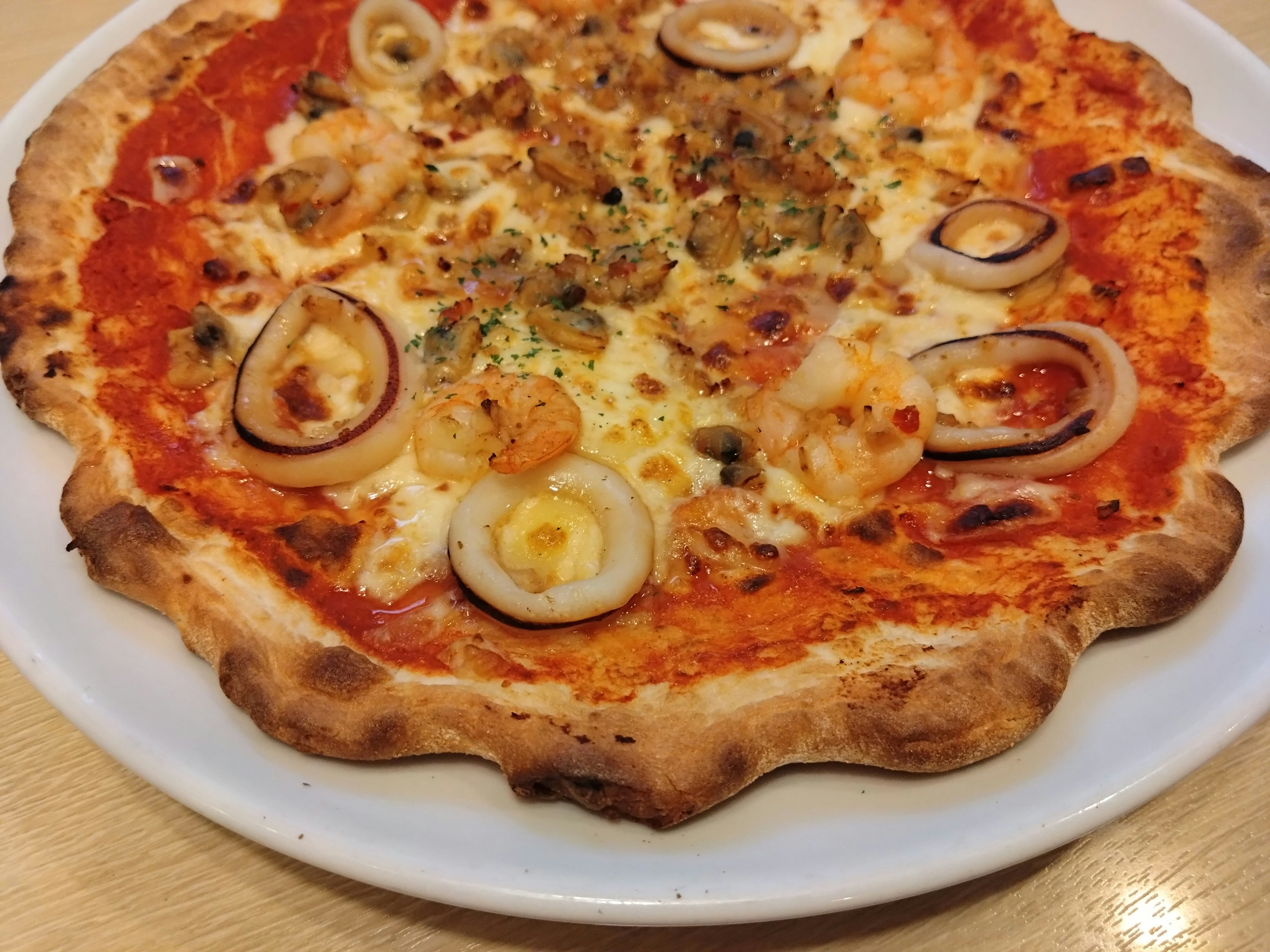 Pizza belegt mit Garnelen und Zwiebeln