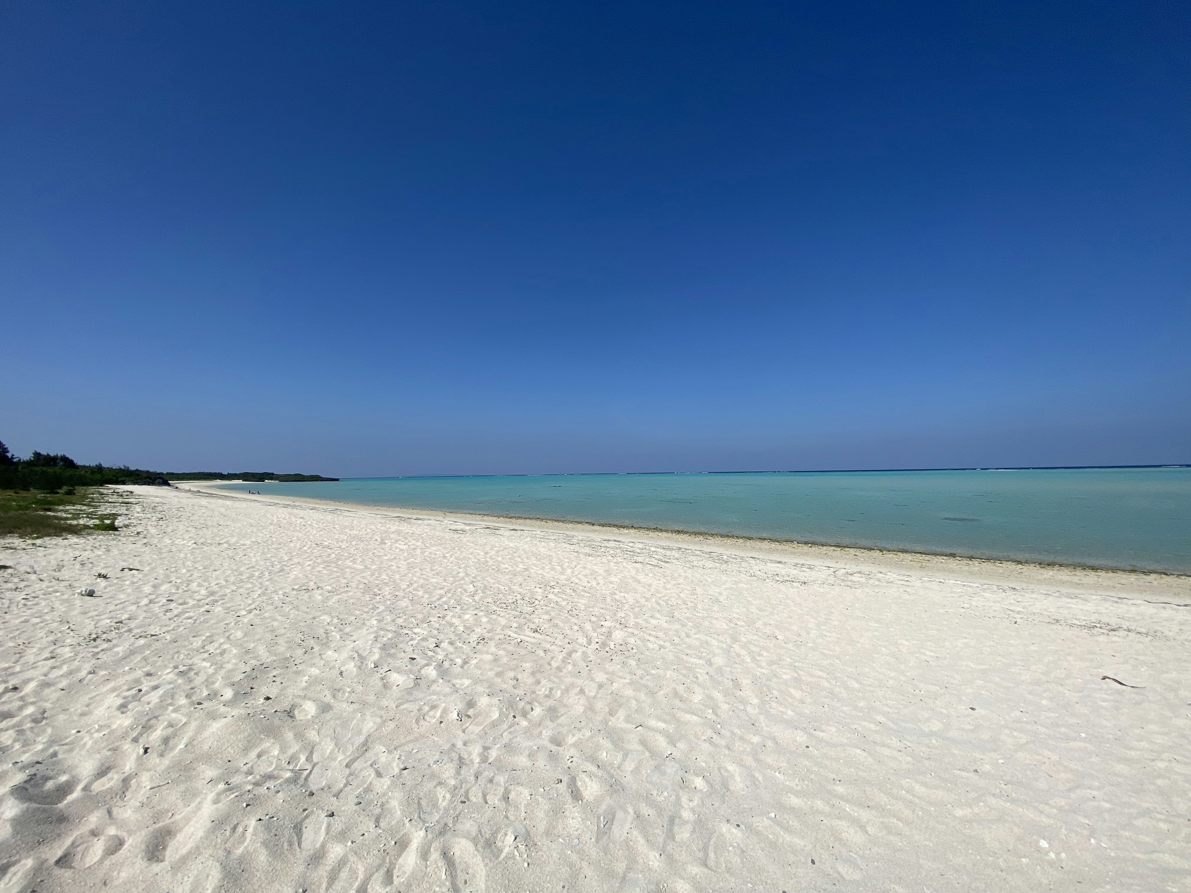 Una spiaggia panoramica con sabbia bianca e cielo blu