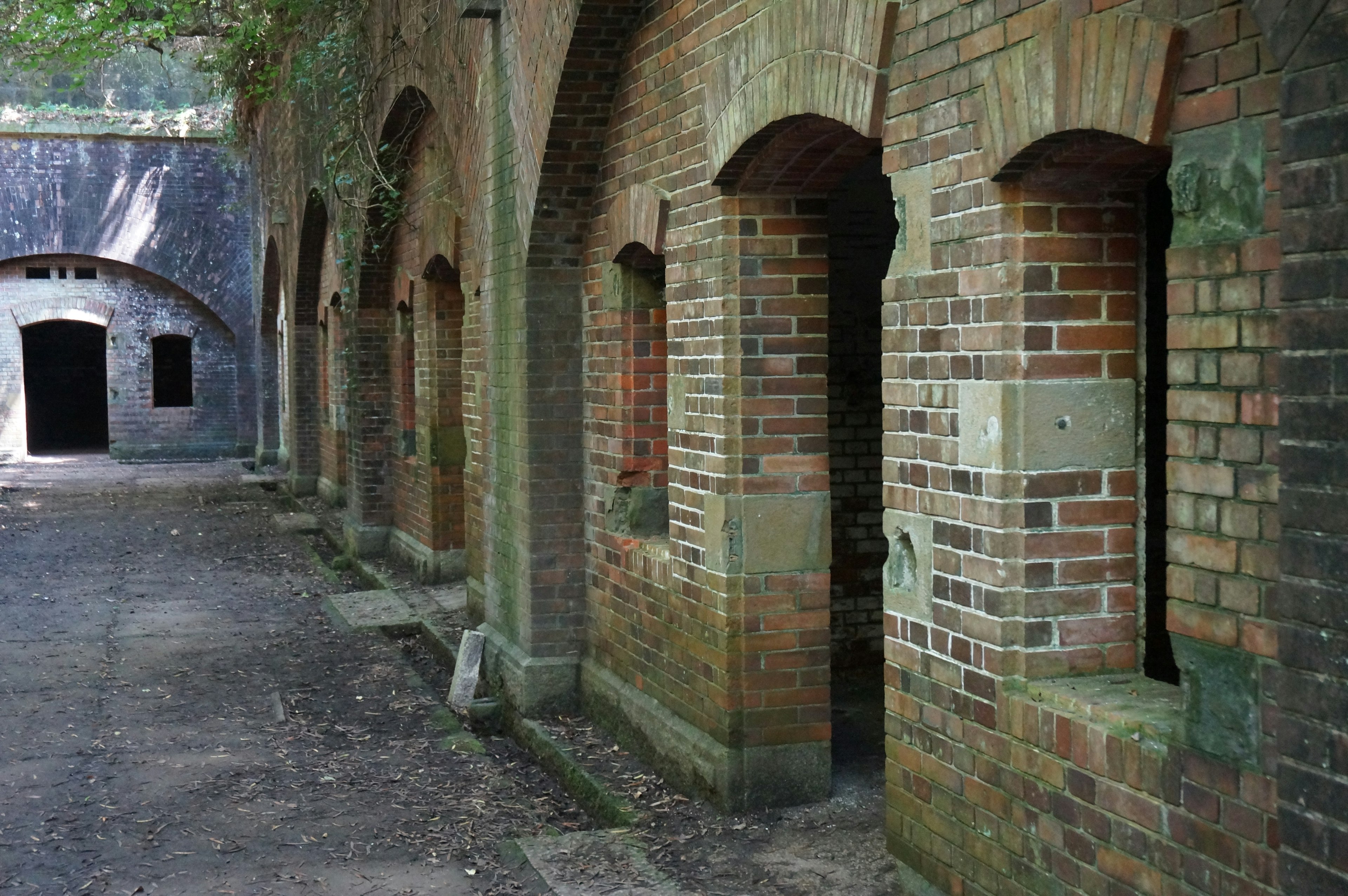 Couloir calme avec des fenêtres et des portes en briques en arc dans un vieux bâtiment