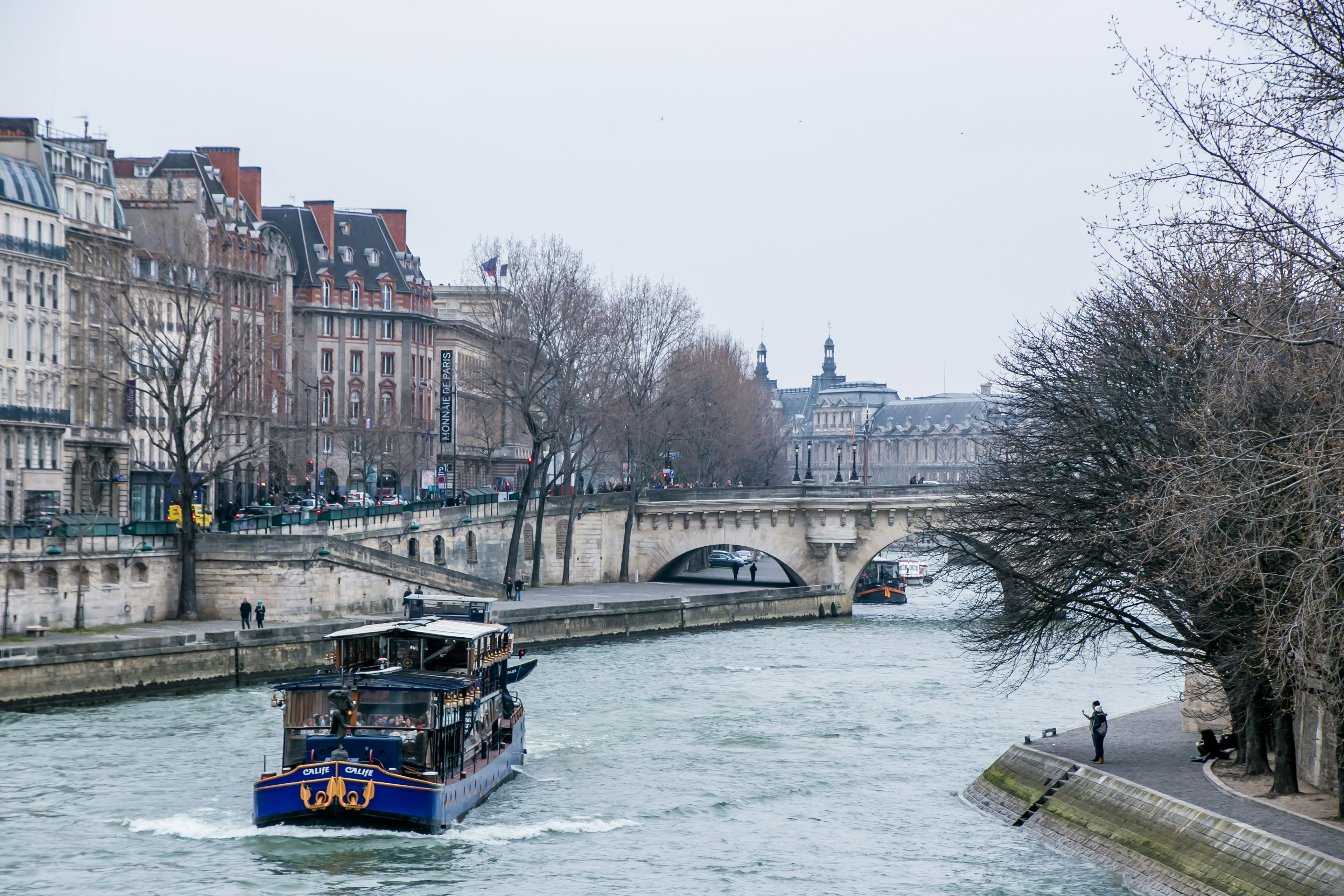 Scena di una barca che naviga sul fiume Senna con edifici storici