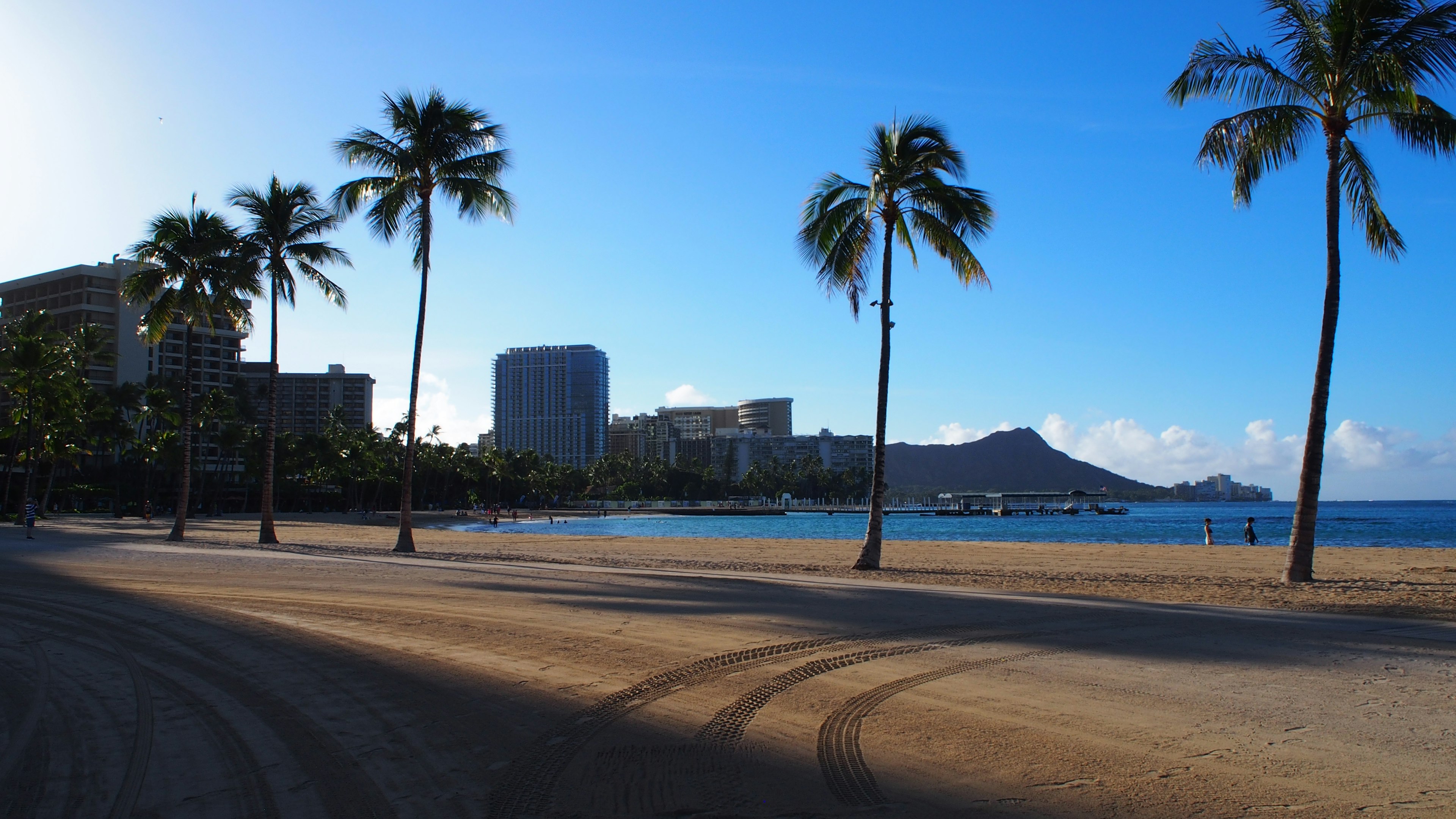 Vue de plage pittoresque avec ciel et océan bleu présentant des immeubles et la montagne Diamond Head