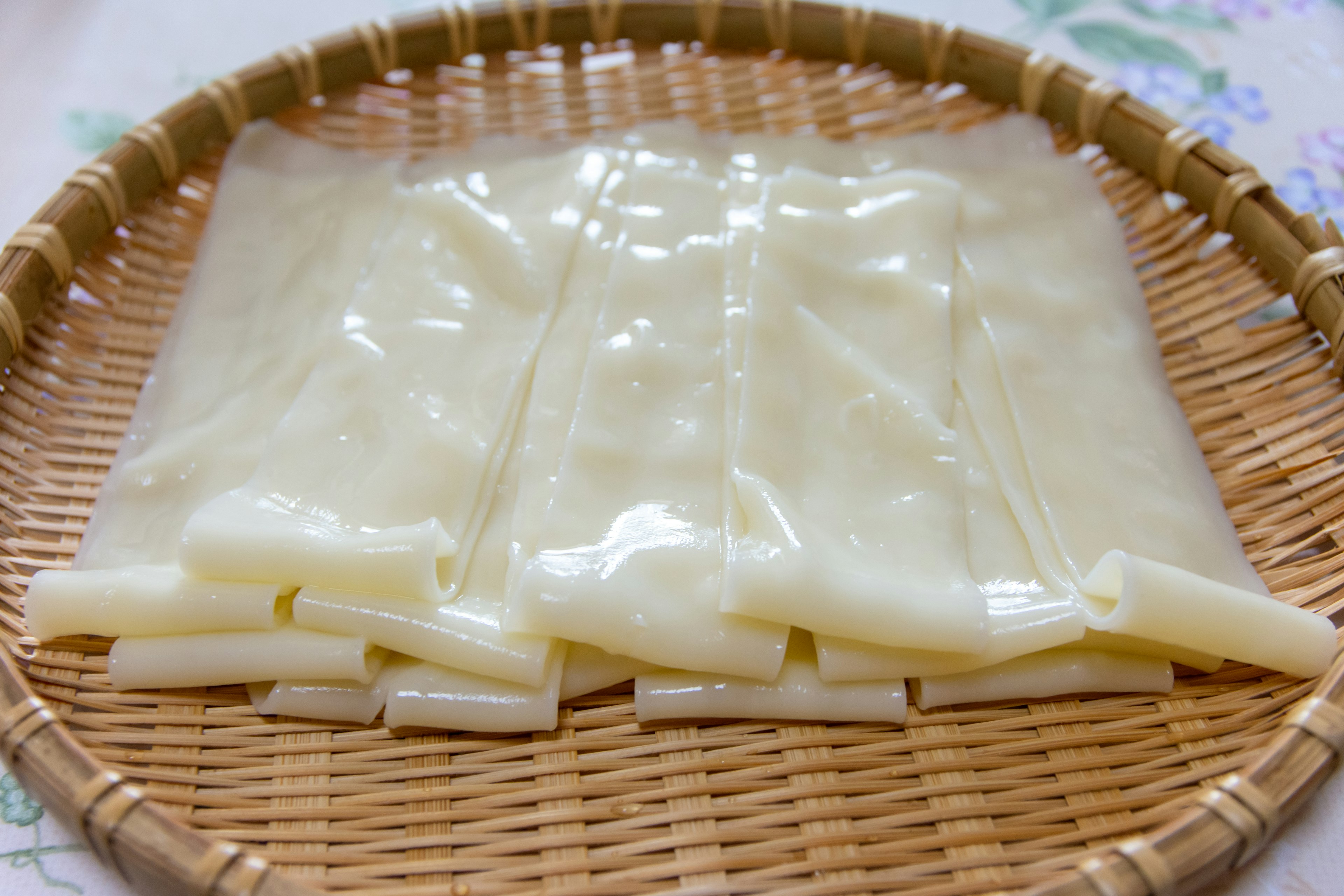 Transparent rice flour sheets placed on a bamboo tray