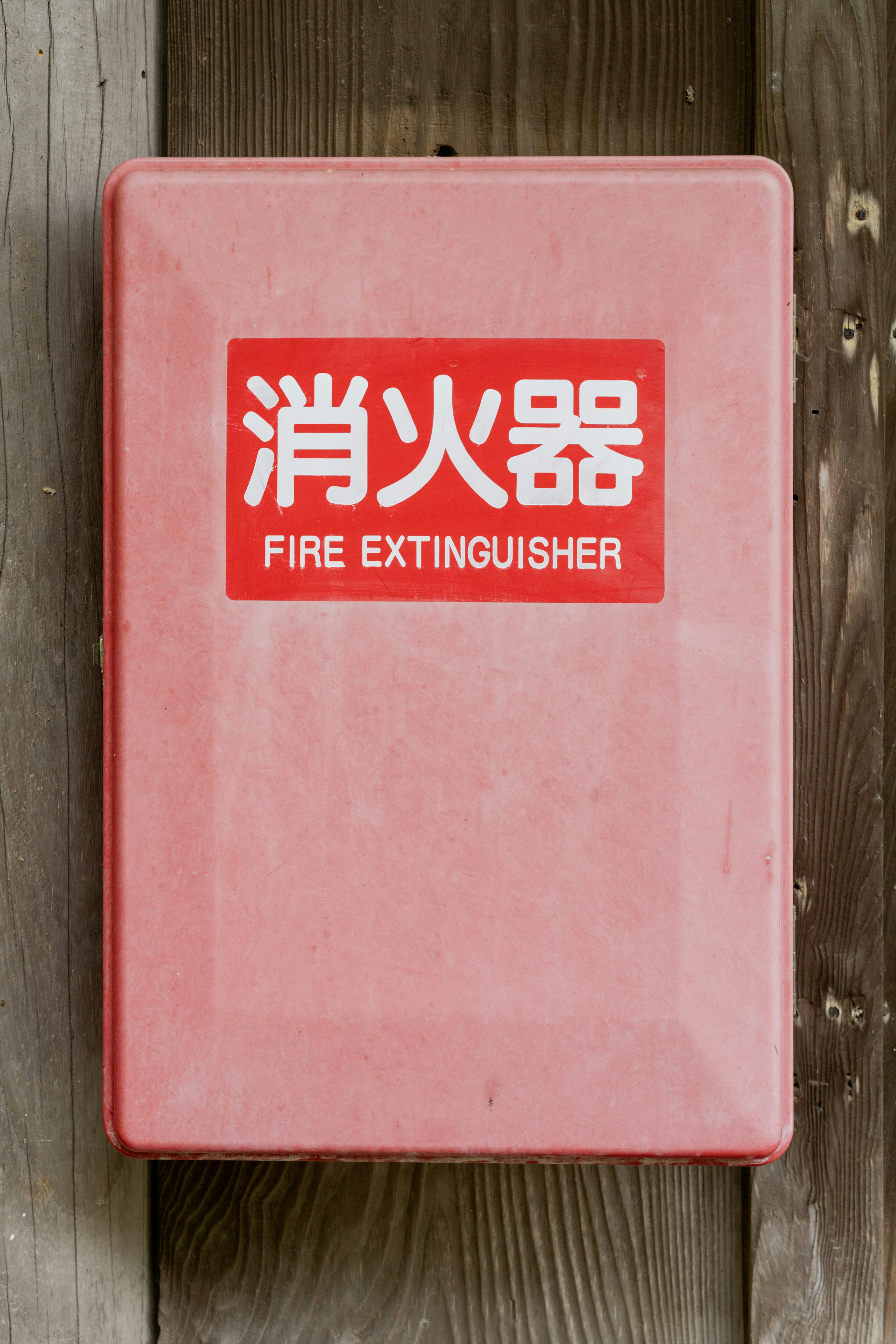 Roter Feuerlöscherkasten mit englischem und chinesischem Text