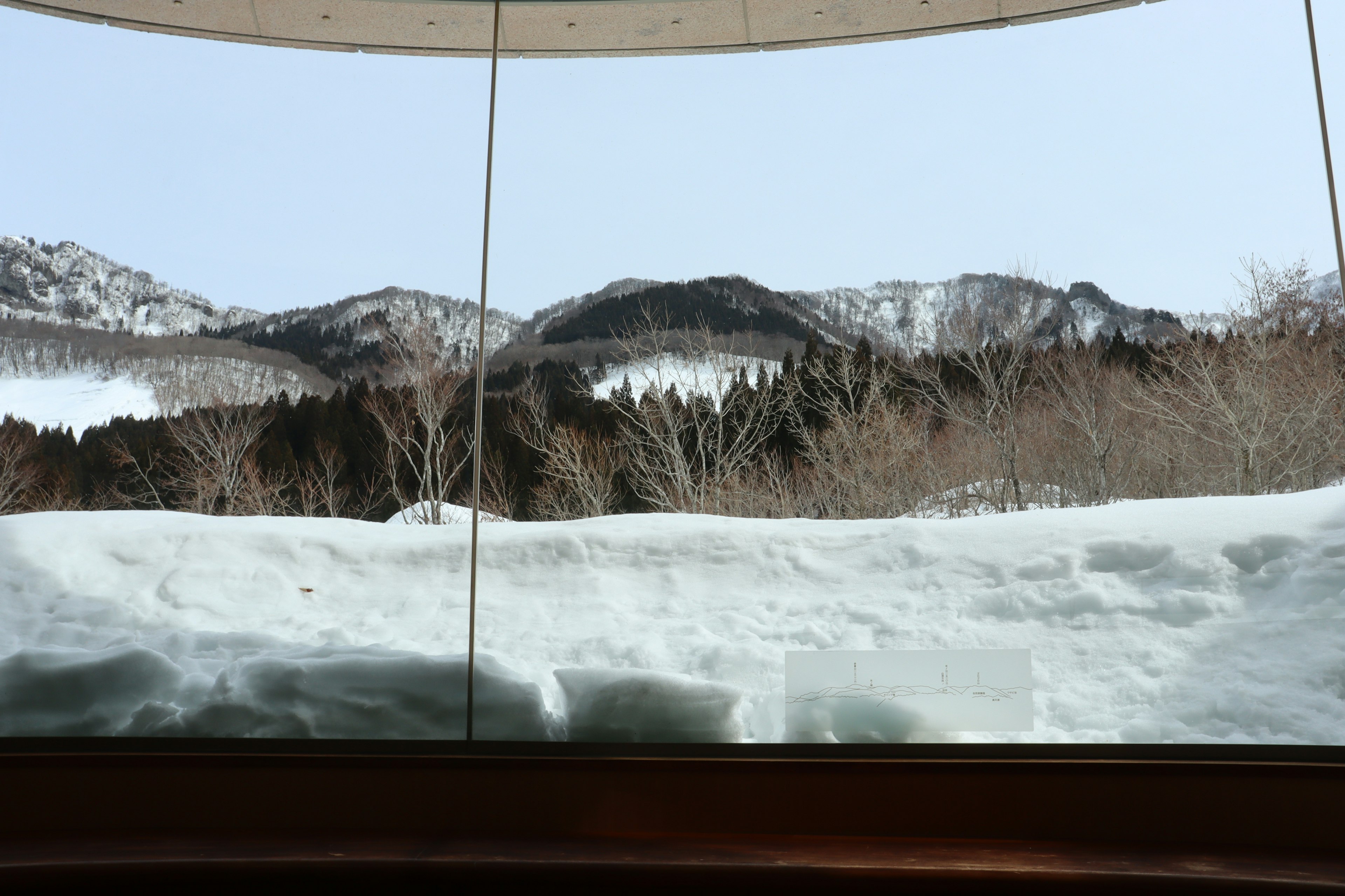 Schneebedeckte Berge durch ein großes Fenster gesehen