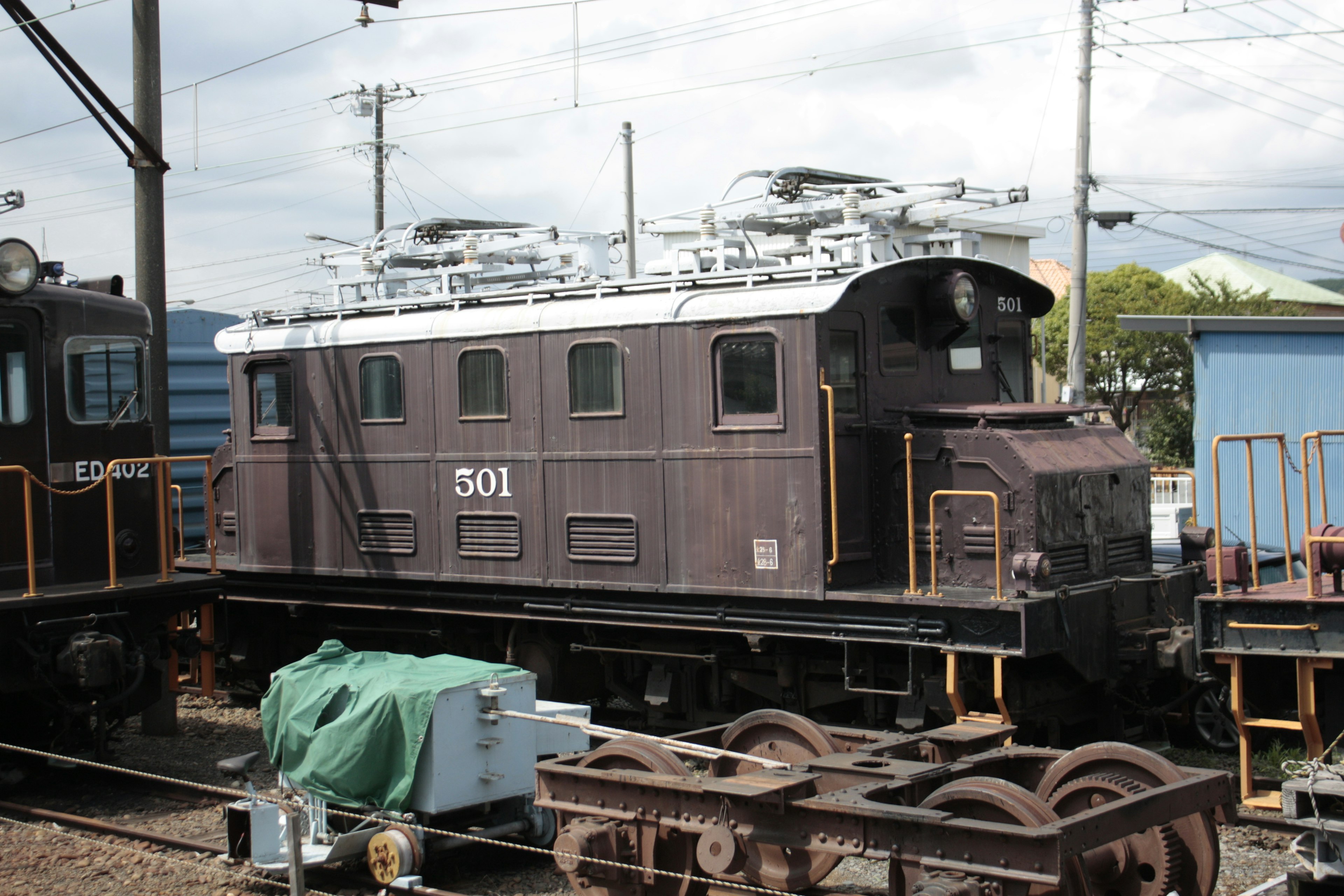 古い電気機関車501が鉄道の車両基地に停車している