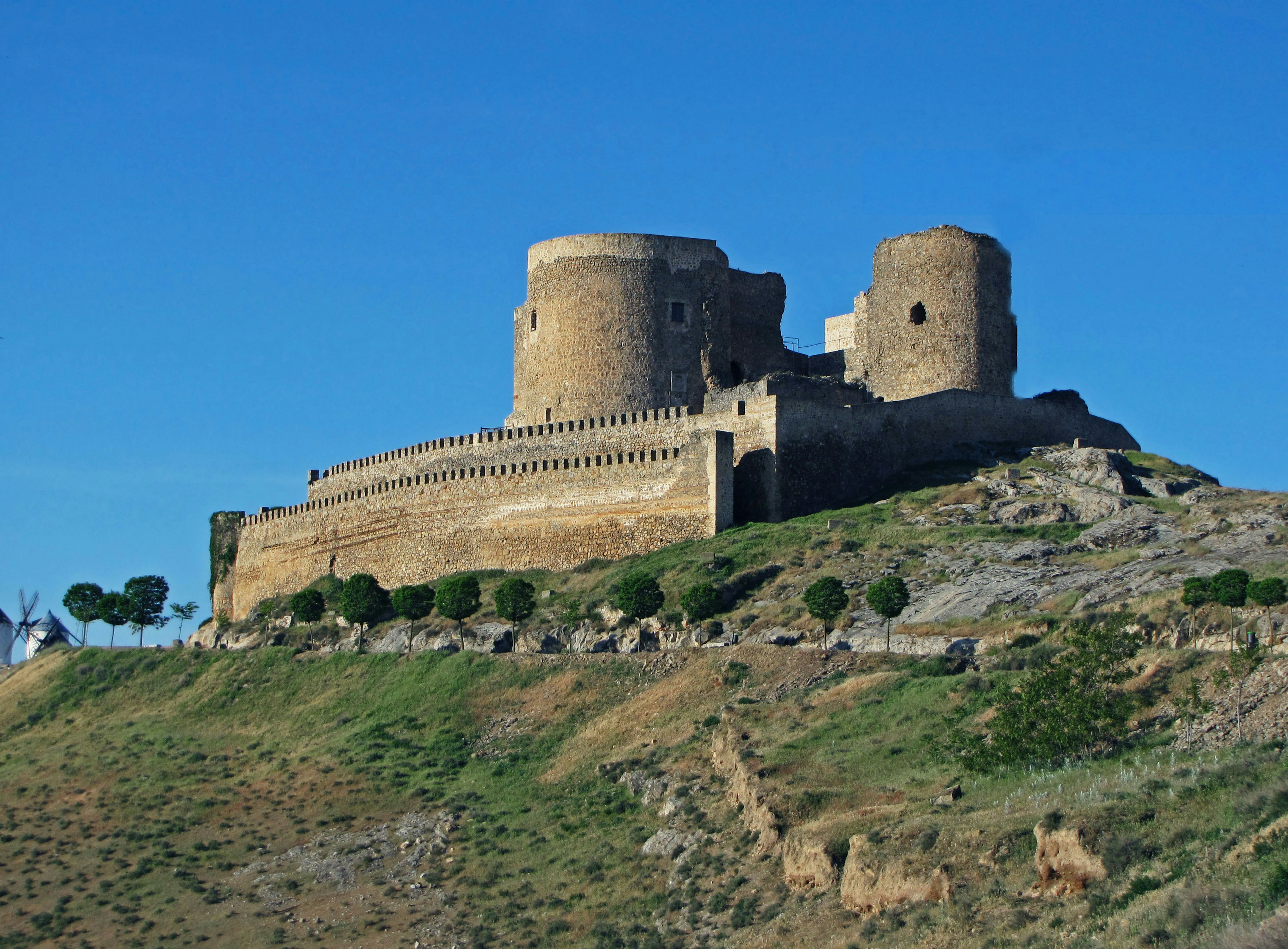 Une ancienne structure de château sur une colline sous un ciel bleu clair