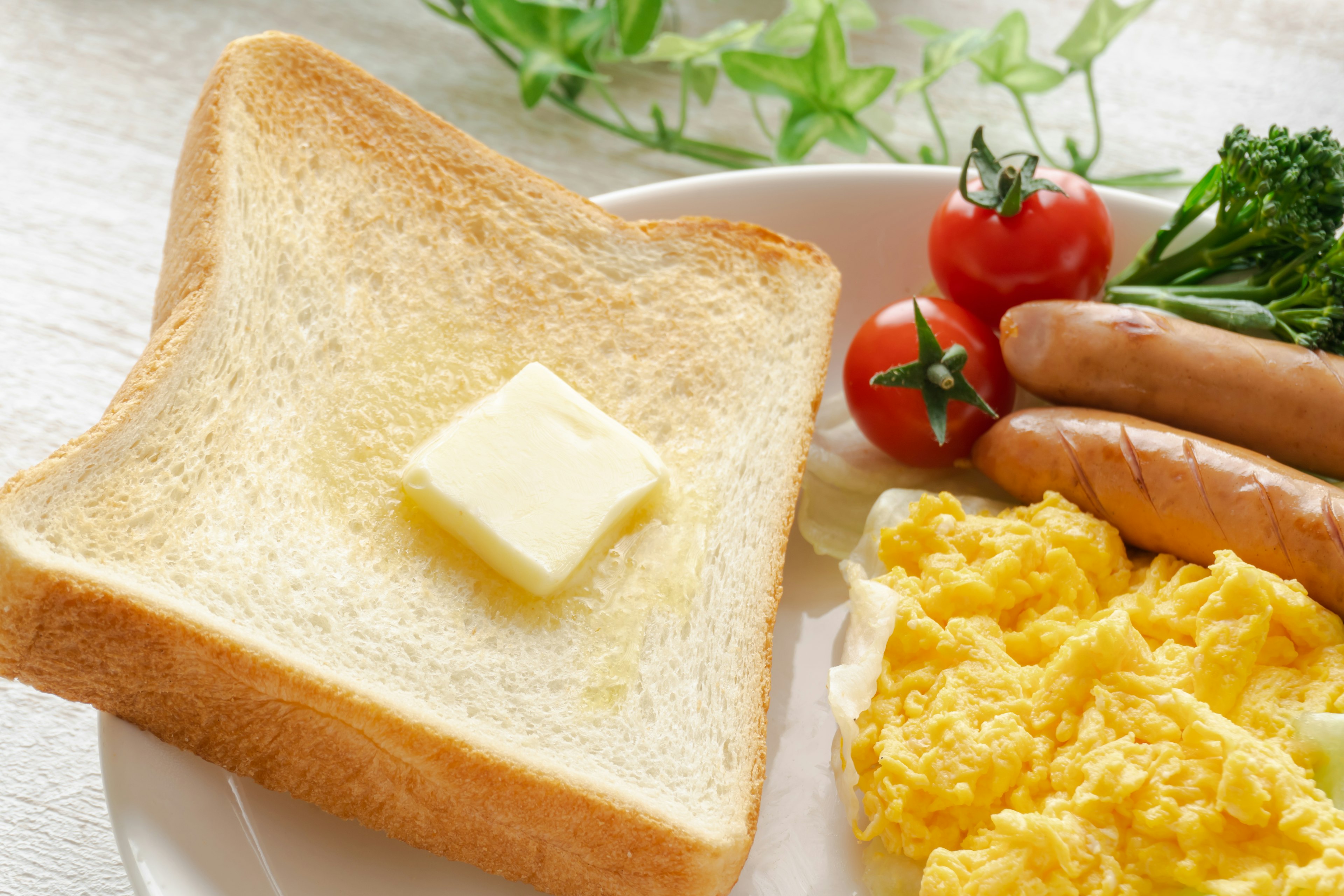 Piatto per colazione con toast con burro uova strapazzate salsicce e pomodorini