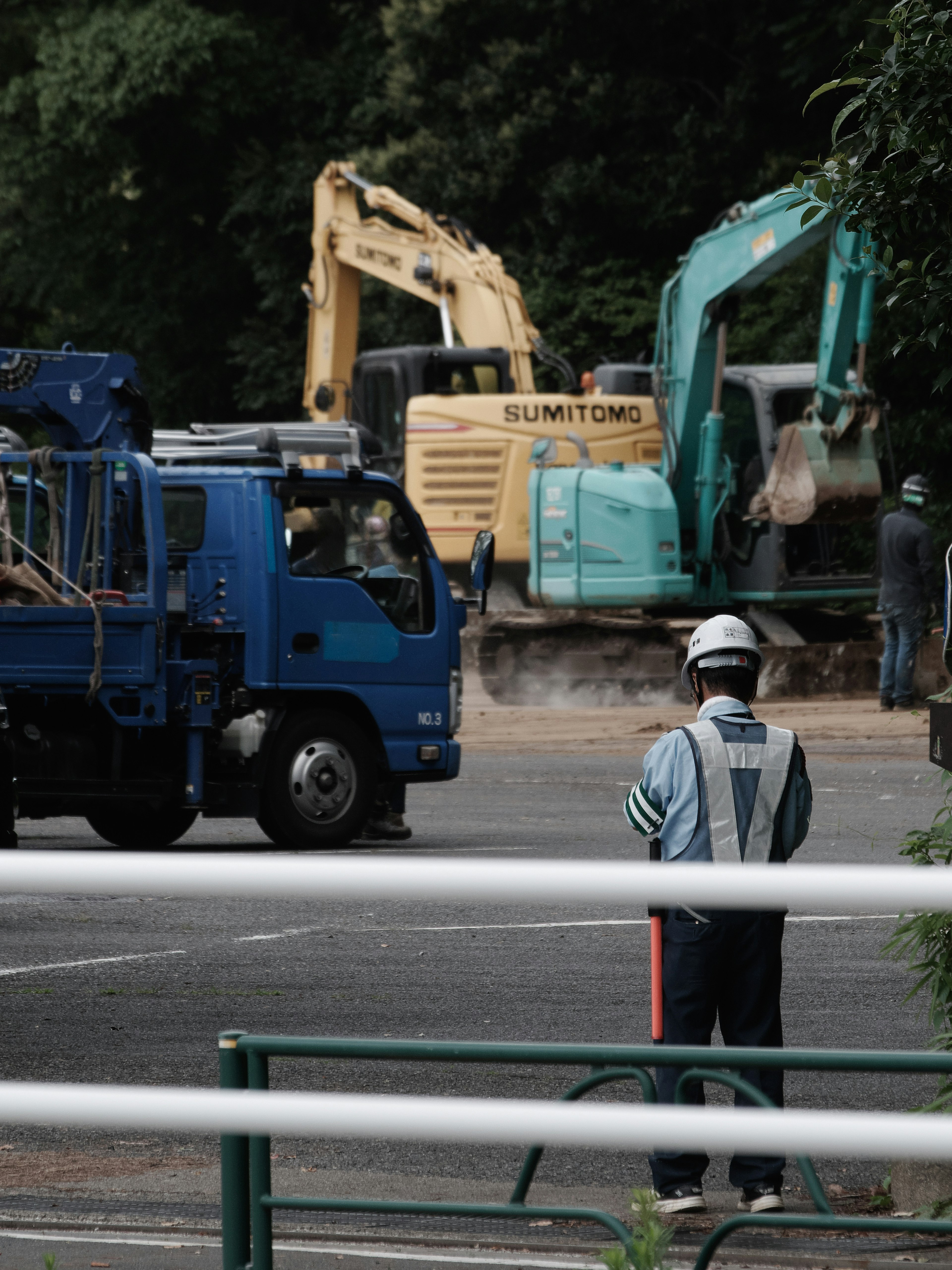 Site de construction avec un camion bleu et des machines lourdes vertes