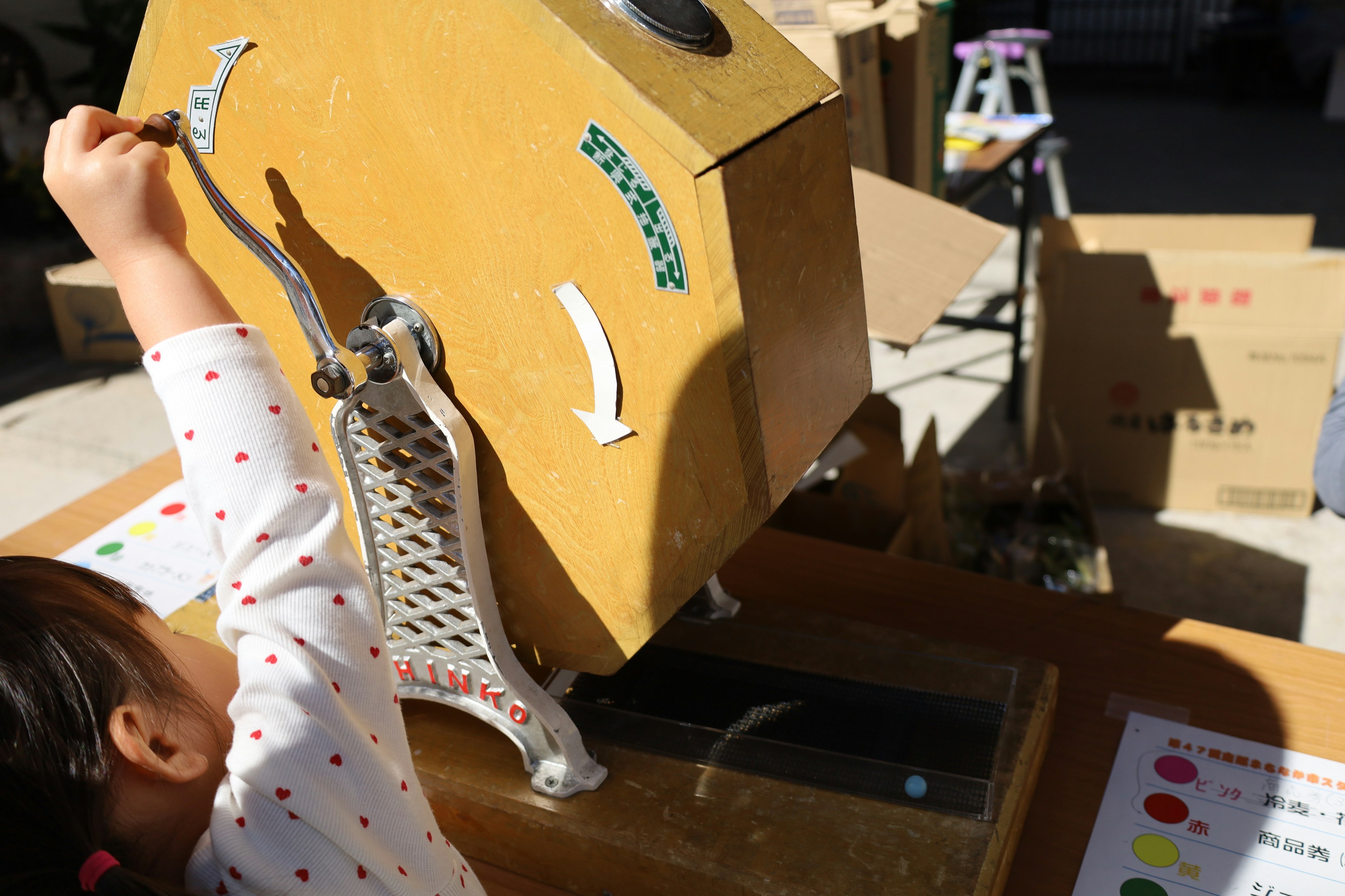 A child operating a vintage manual machine outdoors