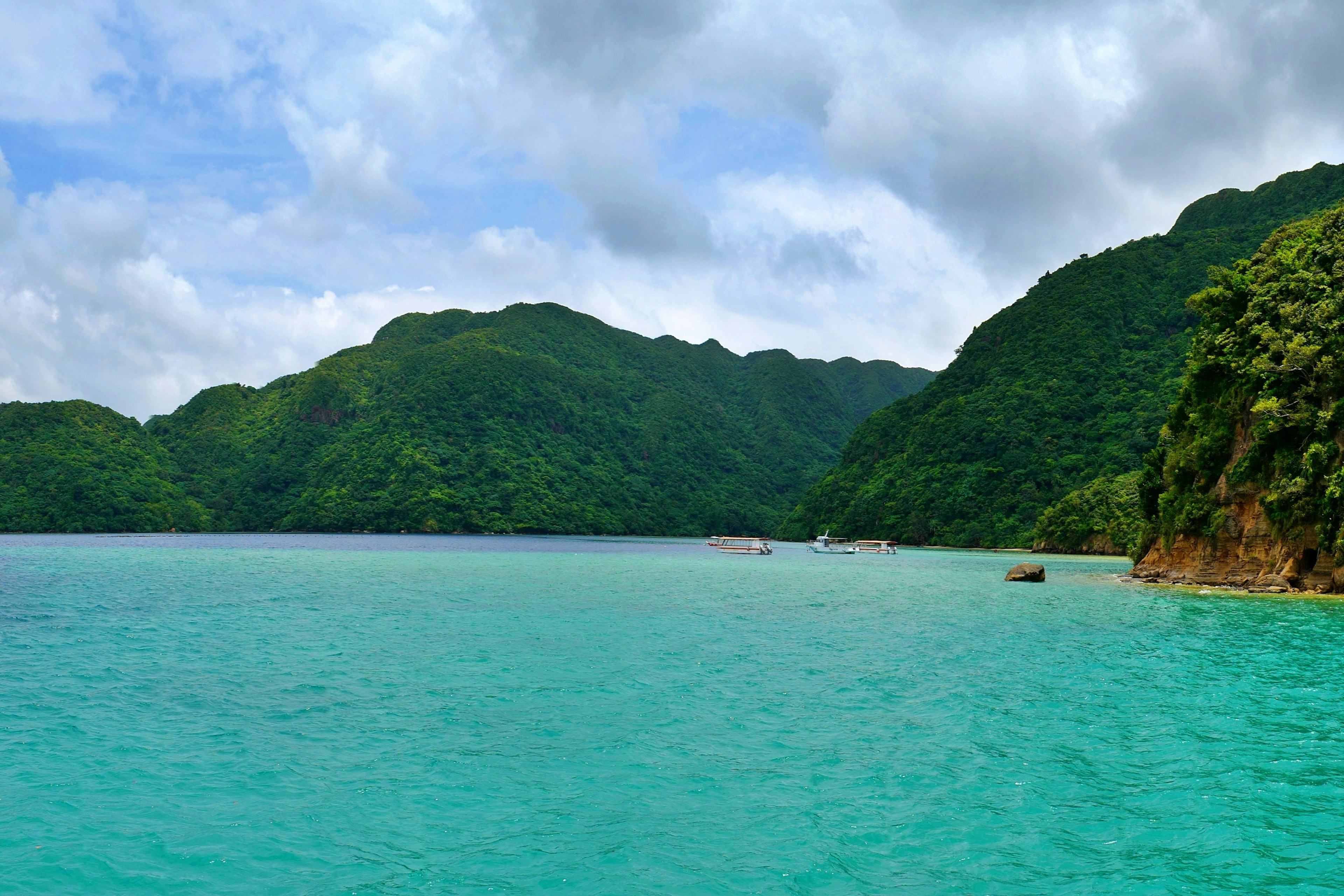 Pemandangan indah air turquoise dengan gunung hijau di latar belakang