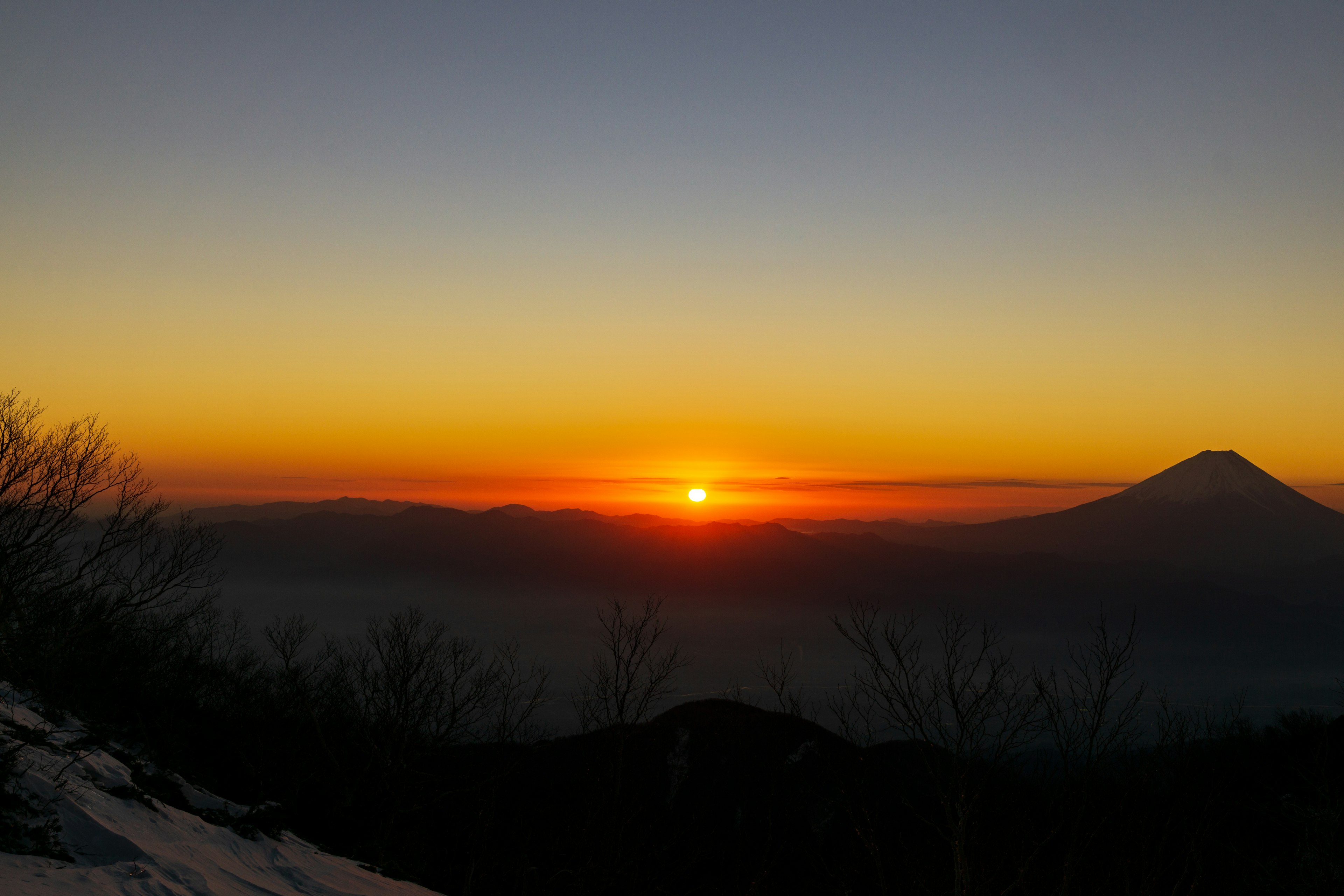 Sunset over mountains with Mount Fuji in the background