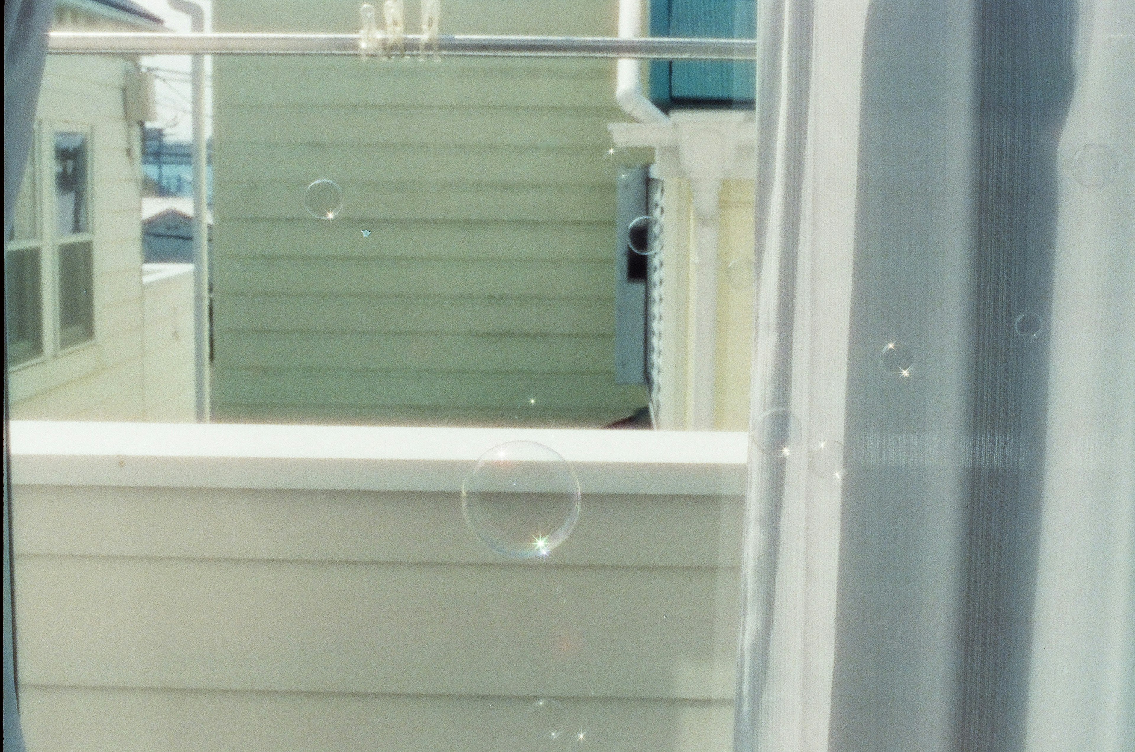 Bubbles visible through a window with colorful houses in the background