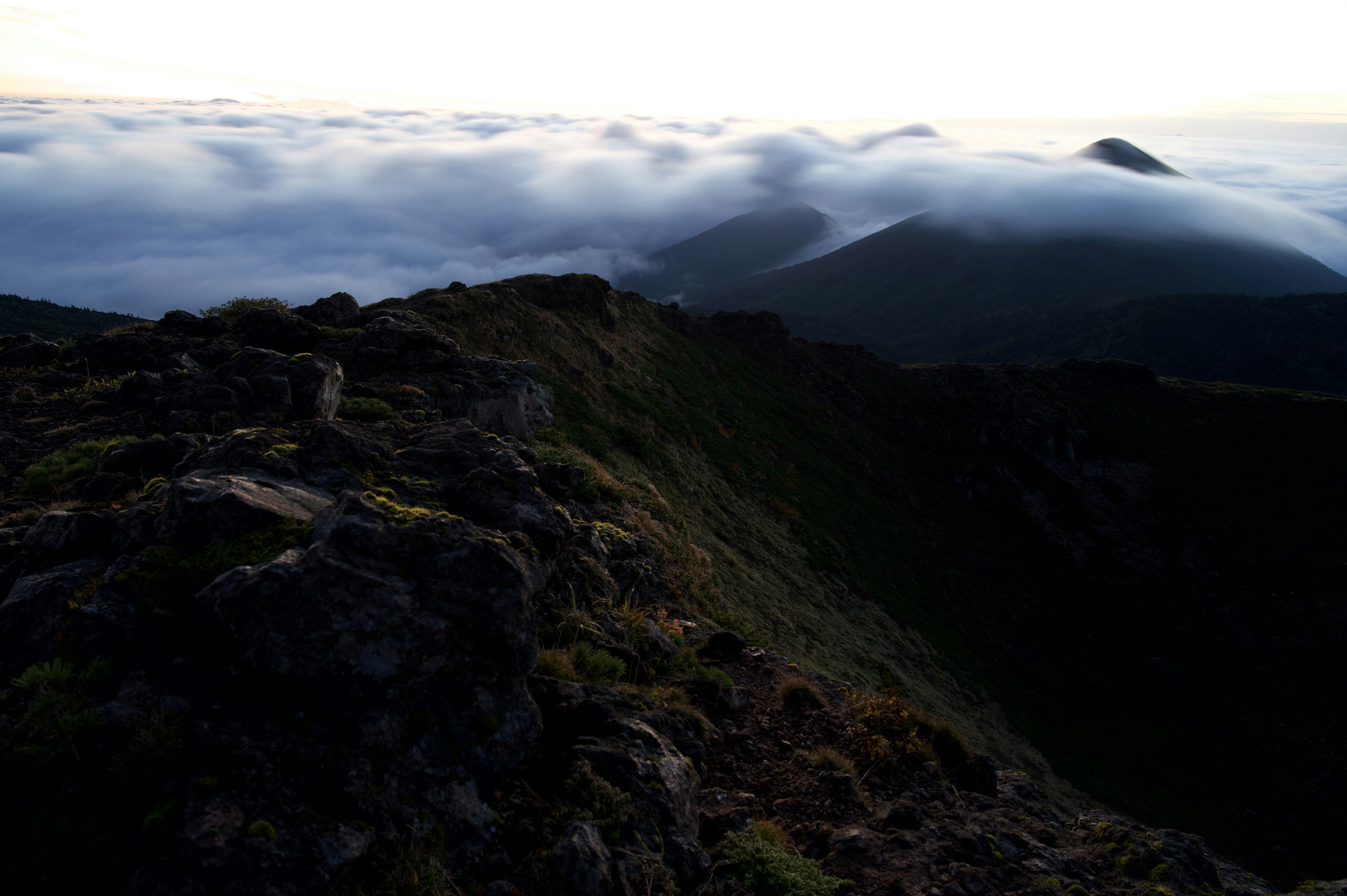 Paysage avec une mer de nuages et des silhouettes de montagnes