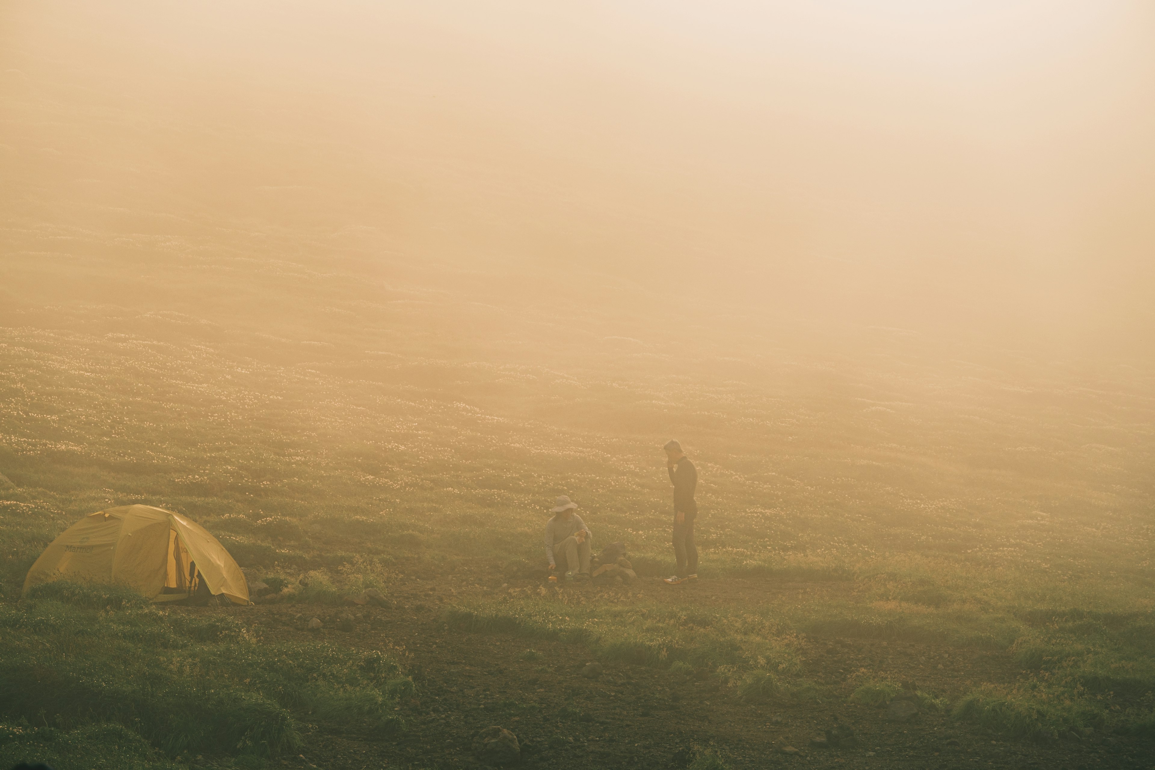 Persone in un campeggio nella nebbia con una tenda