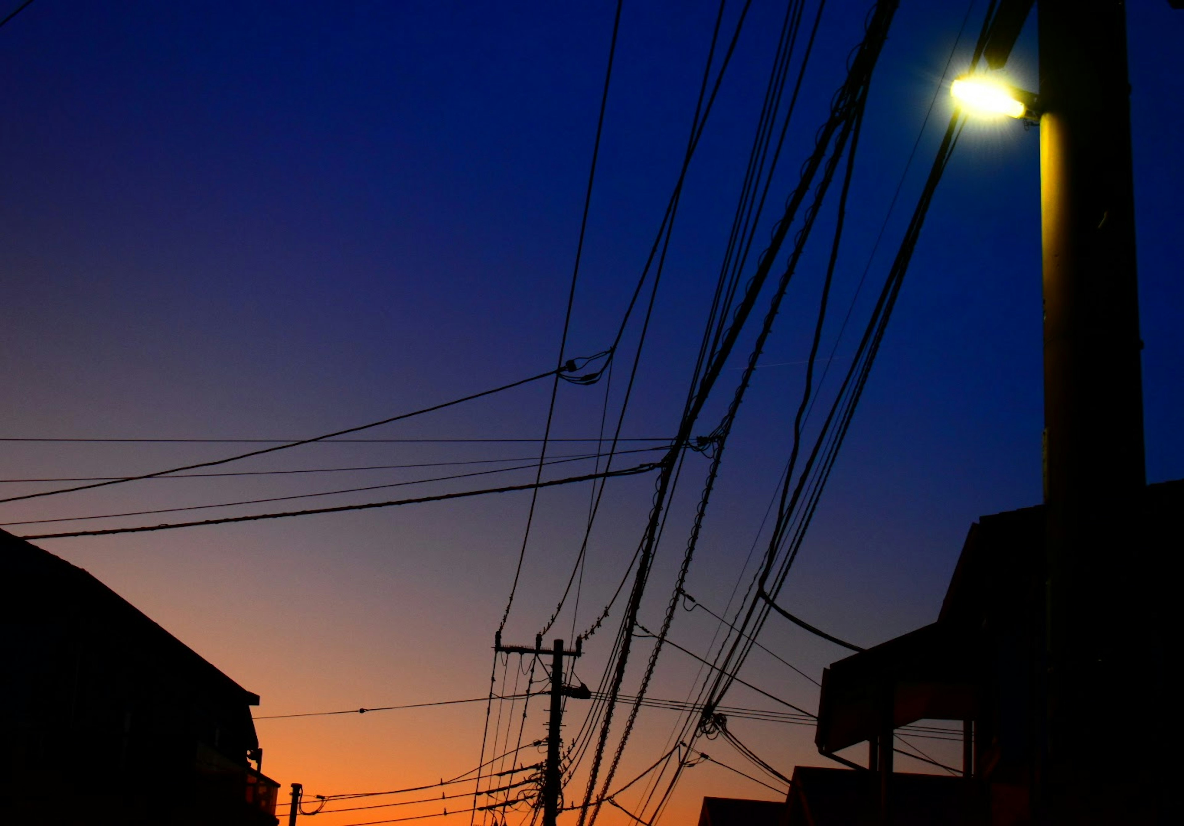 Silhouette de edificios y líneas eléctricas al anochecer